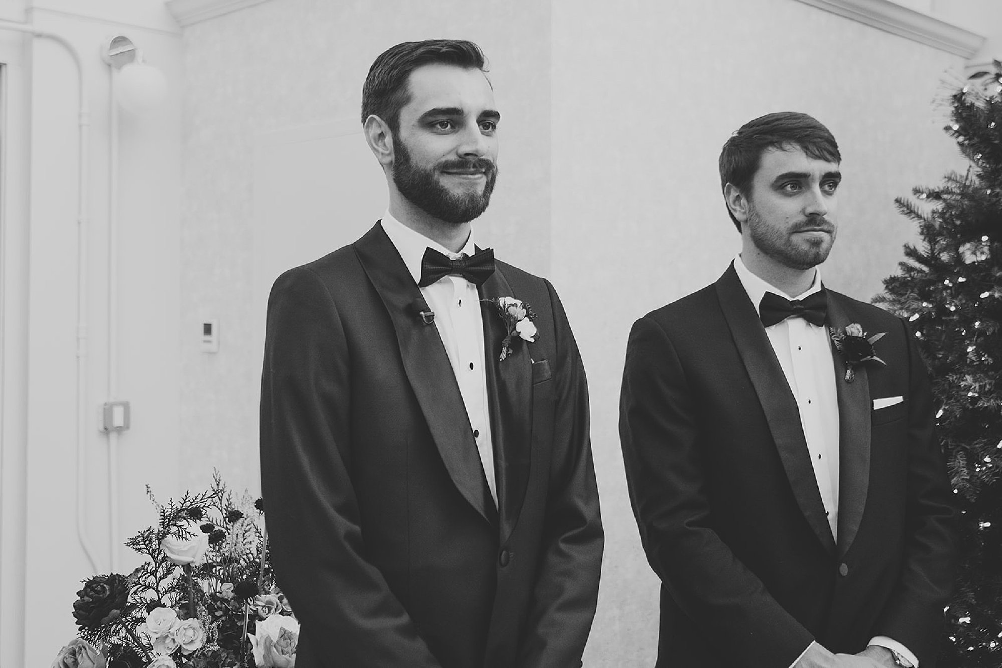 groom stands with groomsman waiting for bride to walk down aisle at The Adelphi Hotel