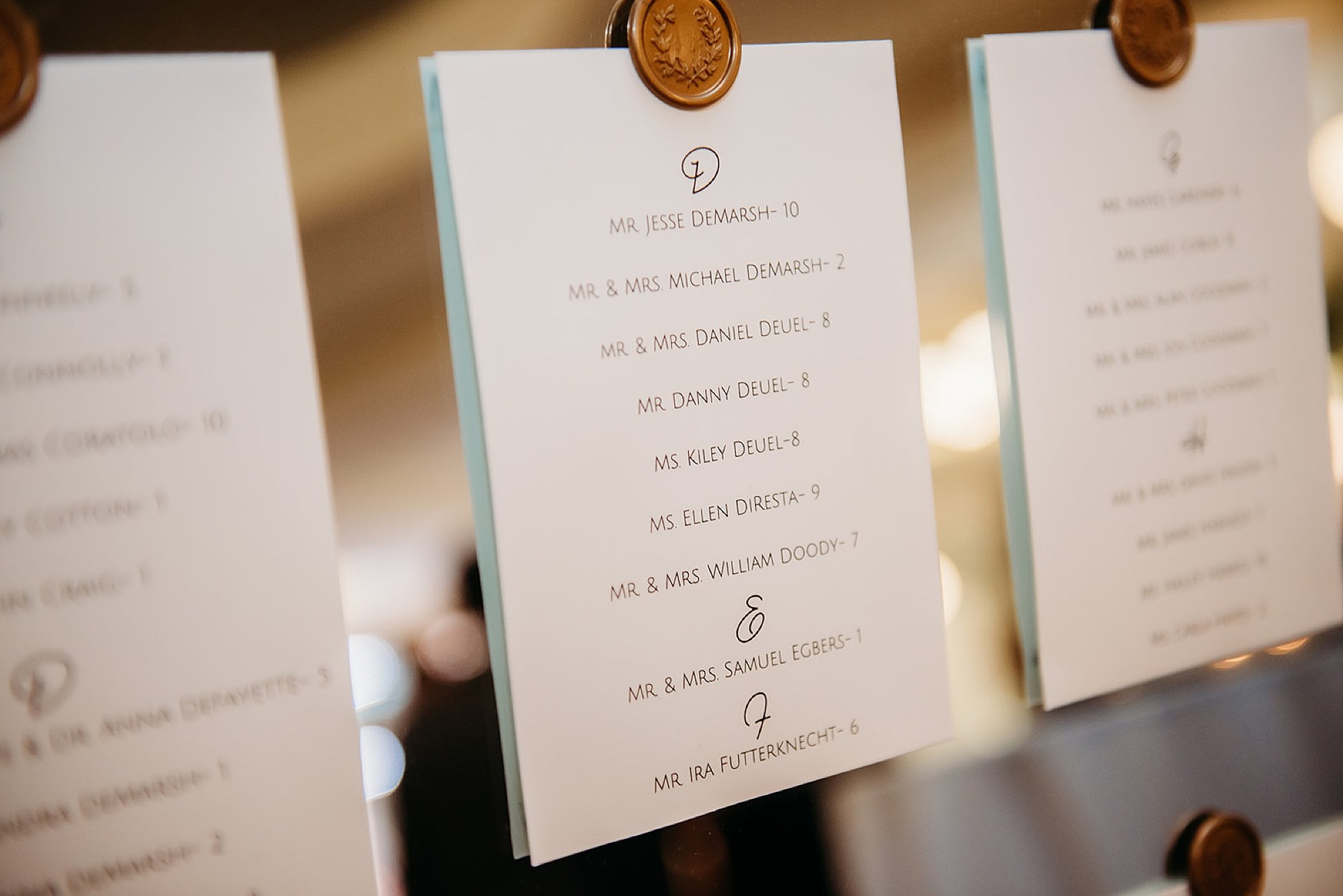 closeup of seating chart held on mirror with wax seal for reception in the atrium at The Adelphi Hotel
