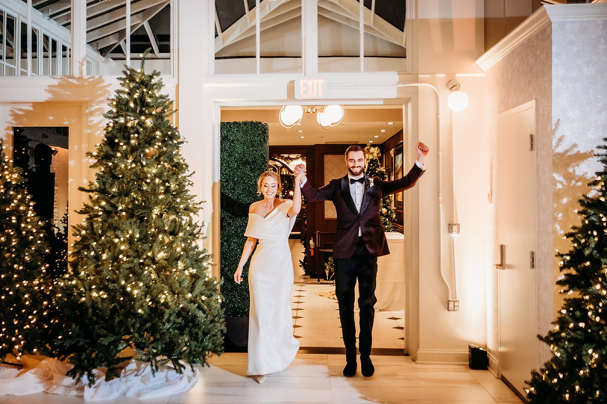 newlyweds wave entering reception in the atrium at The Adelphi Hotel
