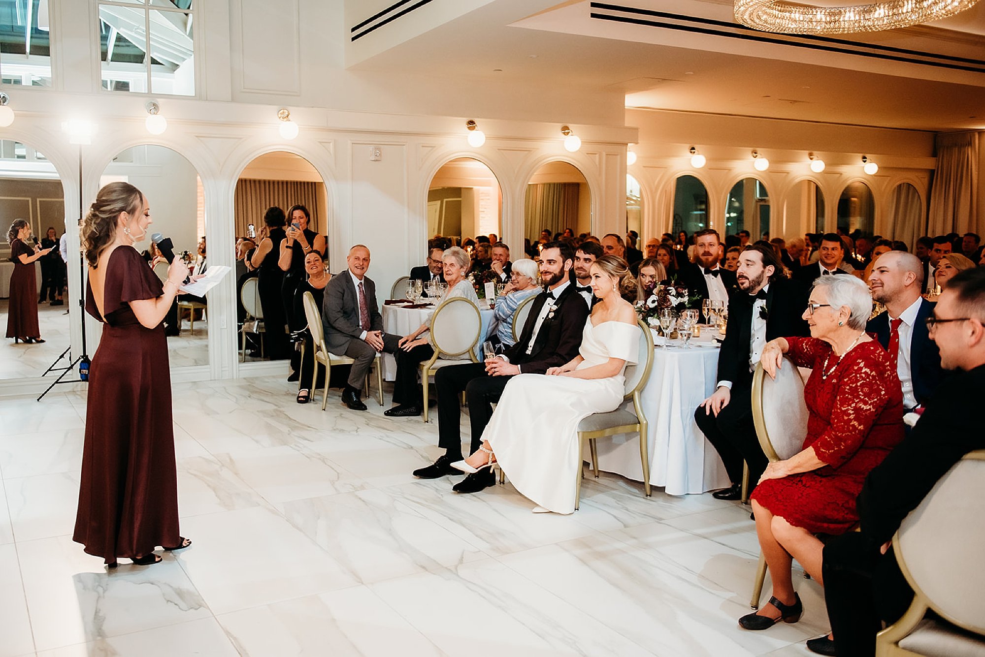 bridesmaid reads speech to newlyweds during reception in the atrium at The Adelphi Hotel