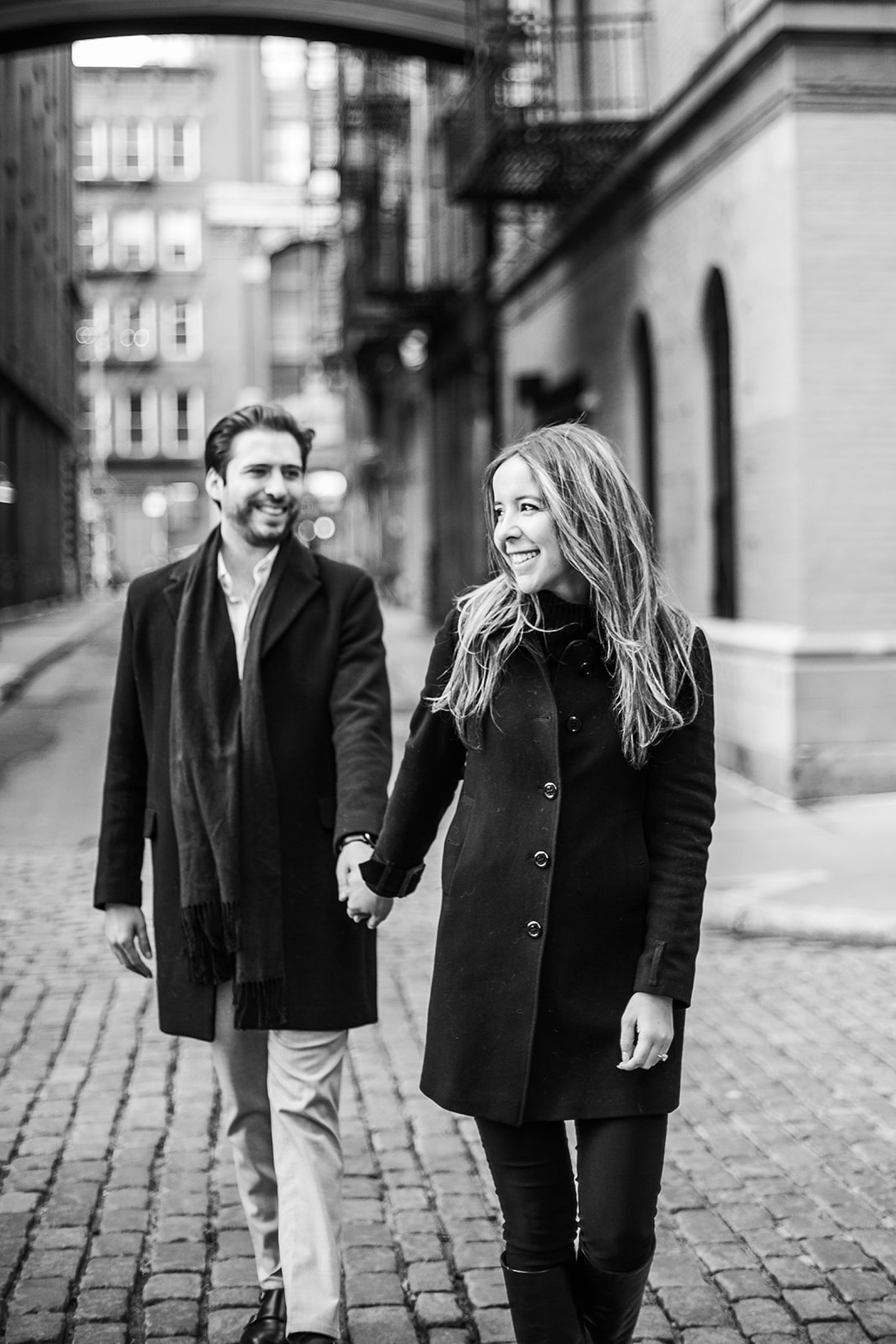 woman holds hand of man walking down streets in Tribeca NY