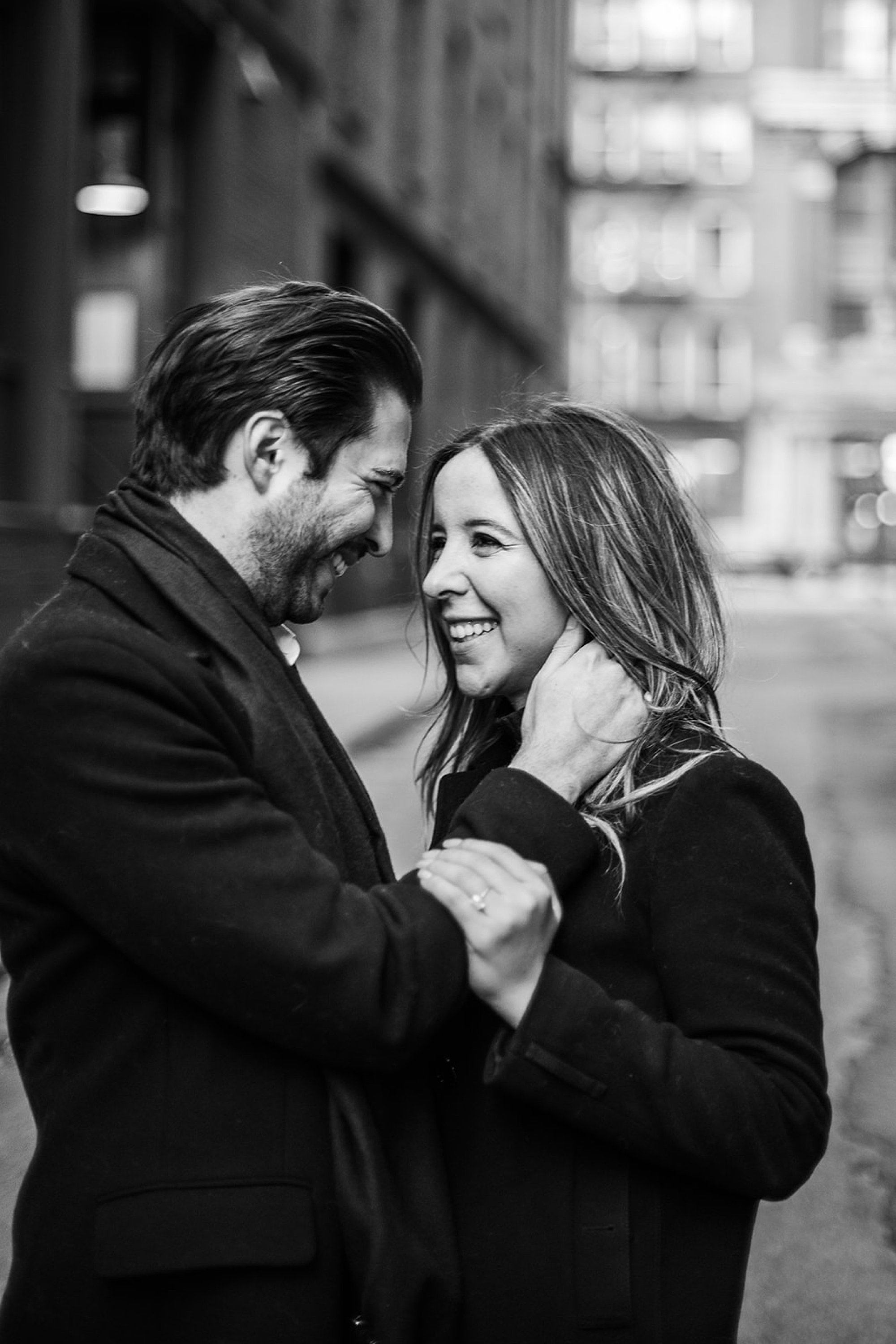 man holds woman's neck smiling at her during classic NYC engagement session in Tribeca NY