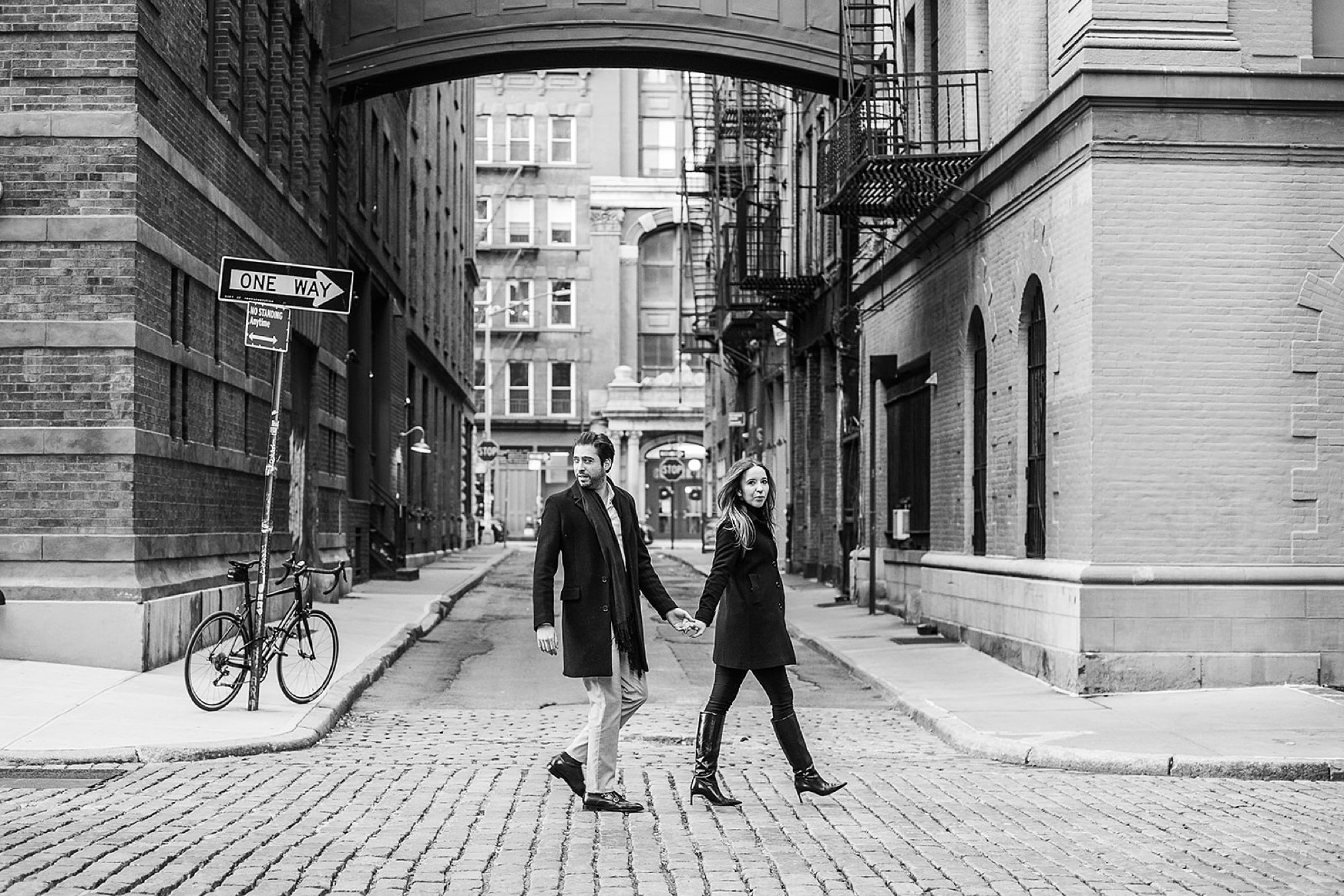 engaged couple holds hands walking down street during classic NYC engagement session in Tribeca NY