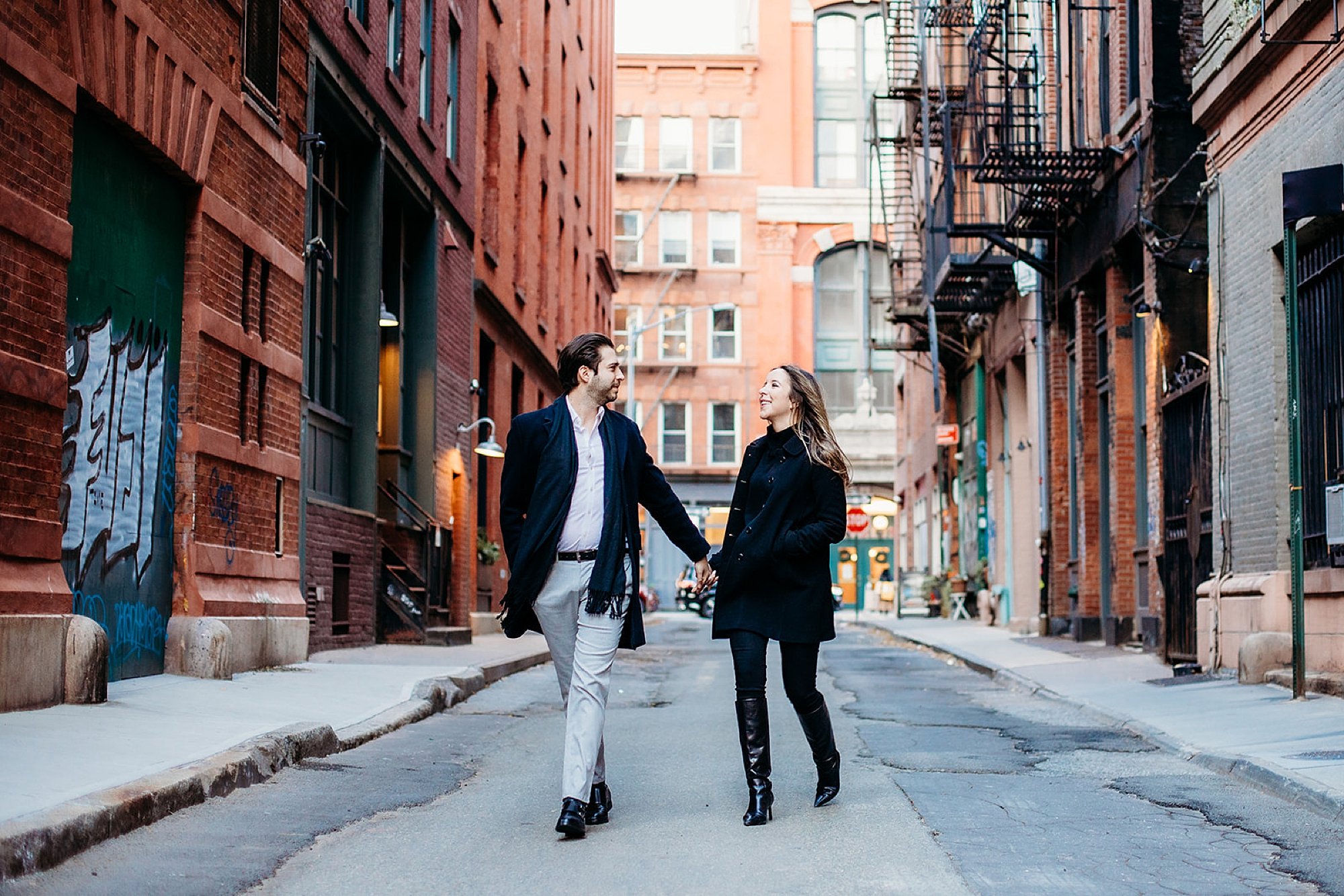 engaged couple holds hands in middle of the street during classic NYC engagement session in Tribeca NY