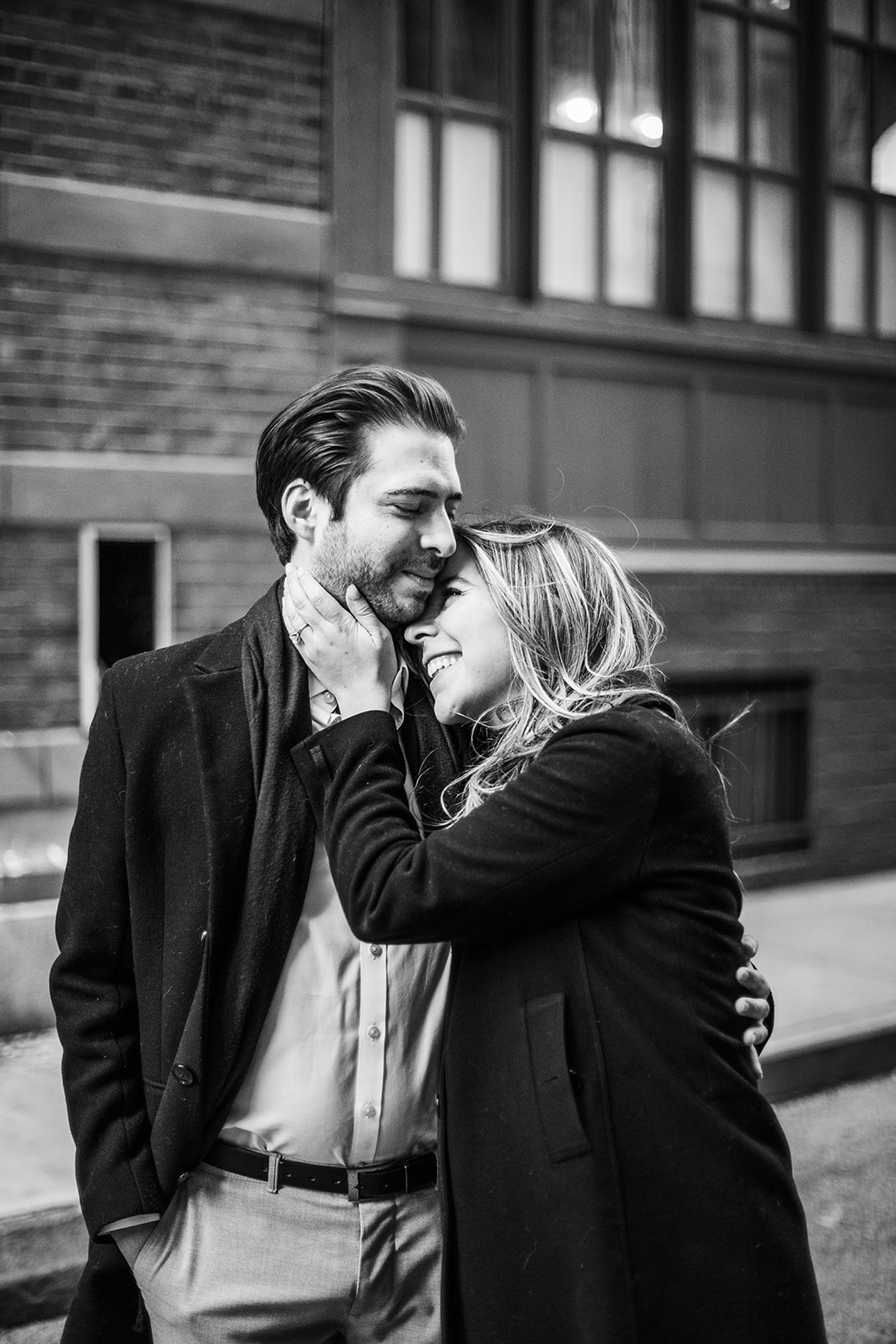 woman hugs man to her during winter engagement session in Tribeca NY