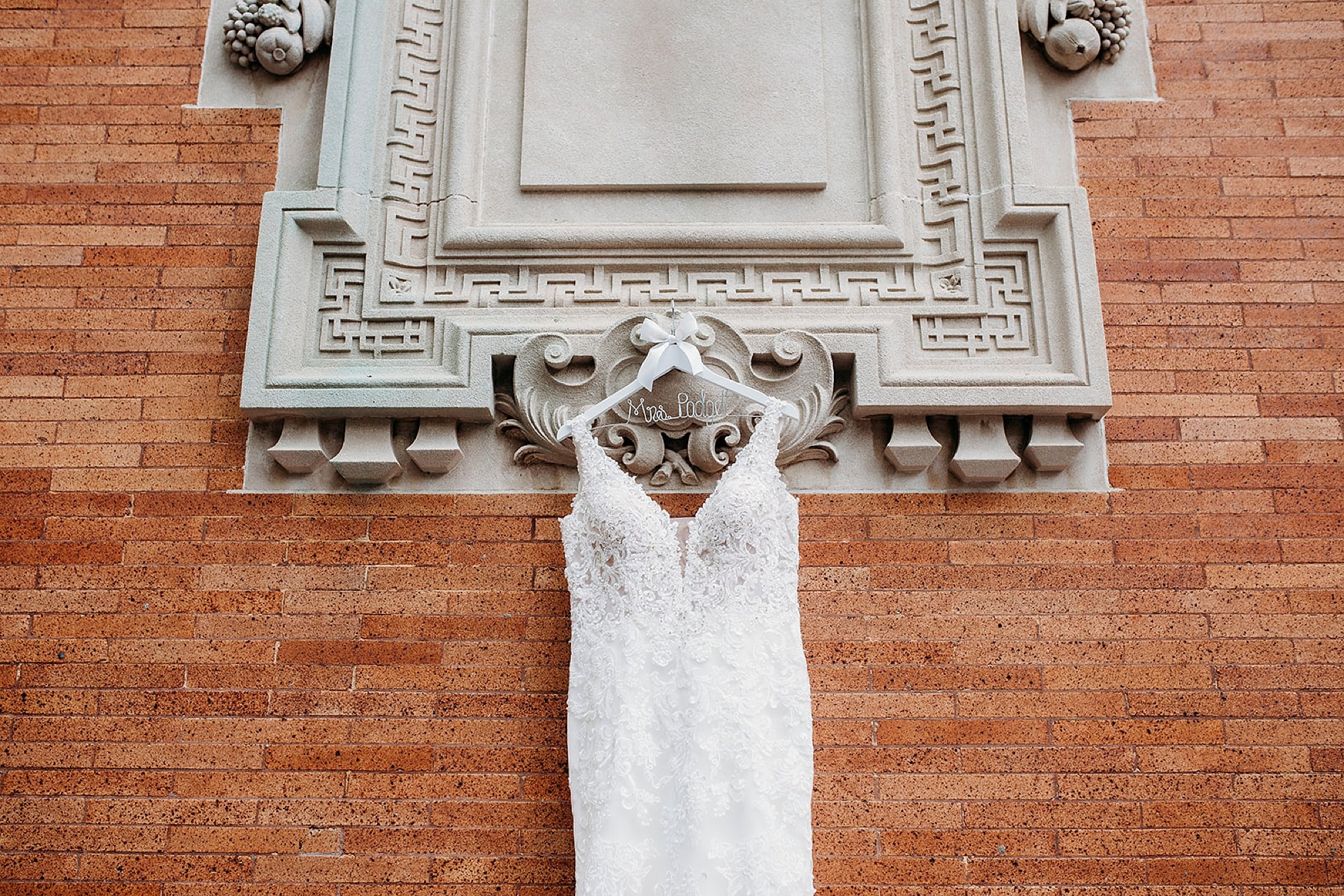 wedding dress hangs on Lion House sign at Bronx Zoo