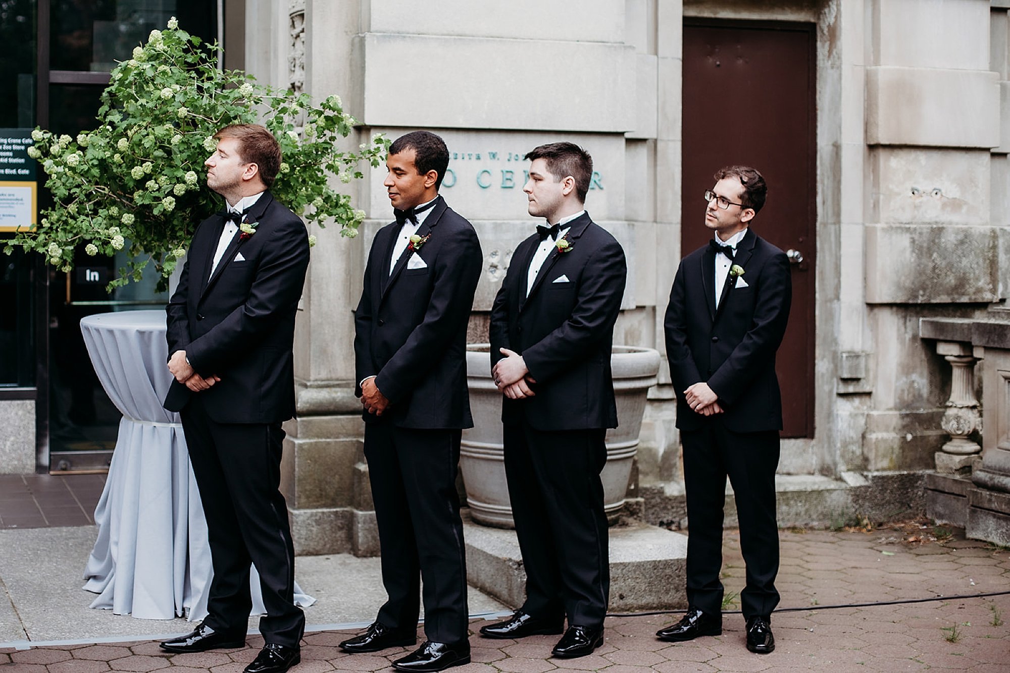 groomsmen stand watching wedding ceremony 