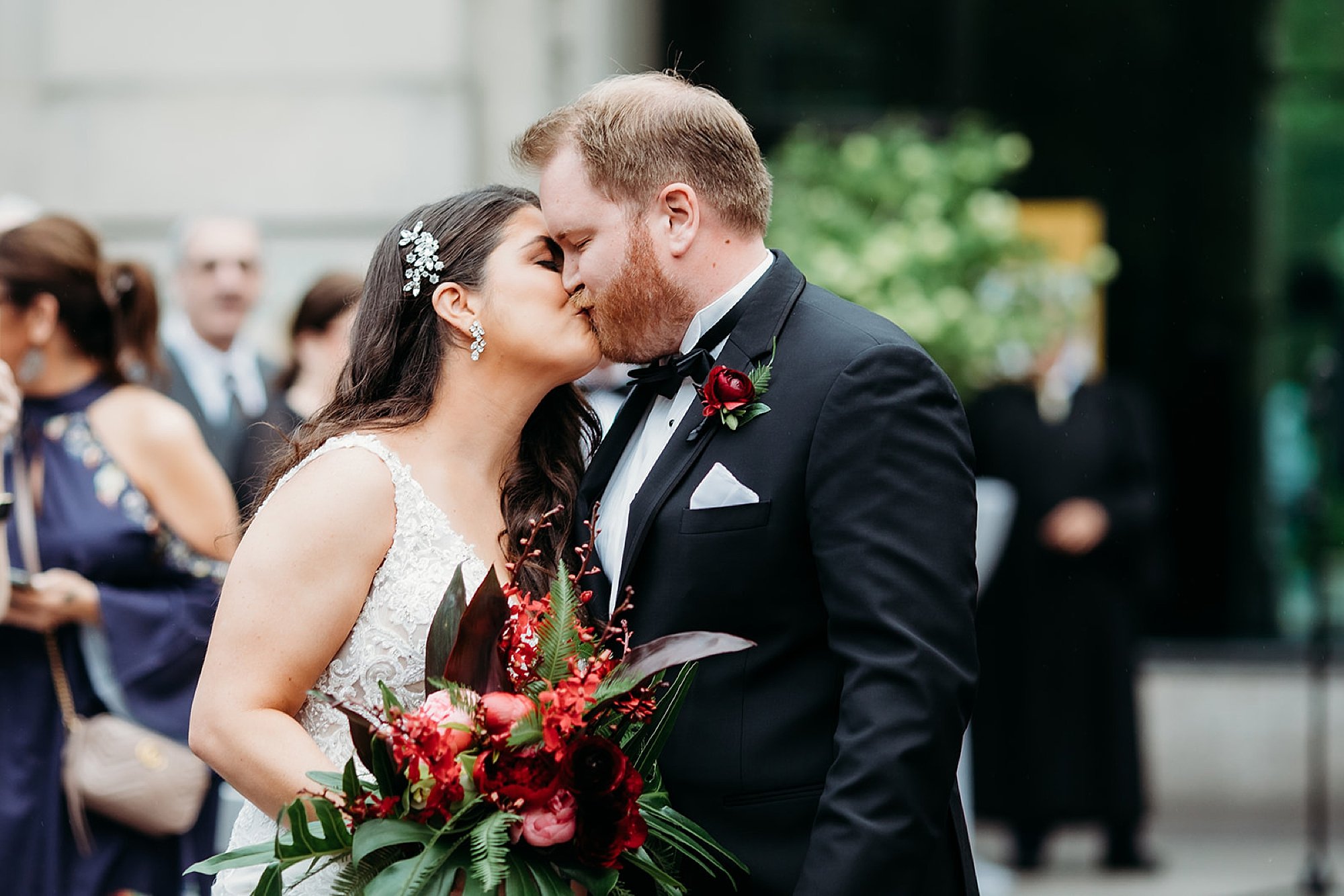 newlyweds kiss during wedding ceremony outside the Elephant House at the Bronx Zoo