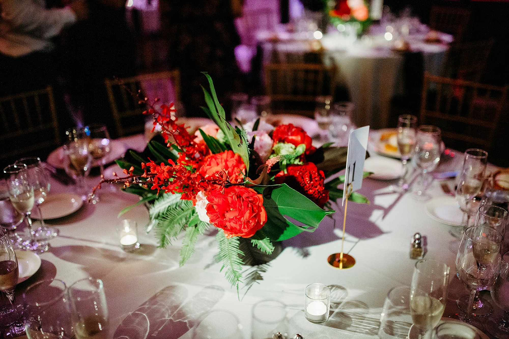 The Bronx Zoo wedding reception at the Old Lion House with red tropical floral centerpieces 