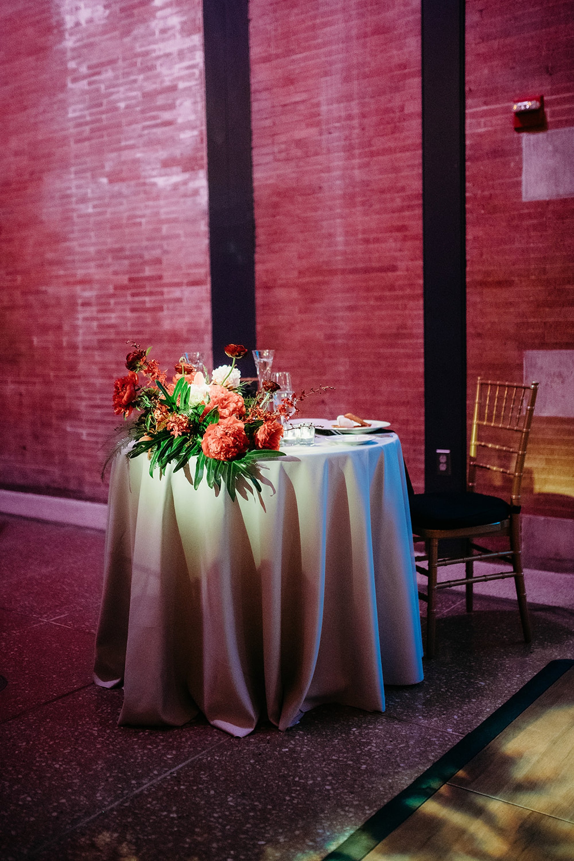 sweetheart table with florals on edge at The Bronx Zoo wedding reception at the Old Lion House