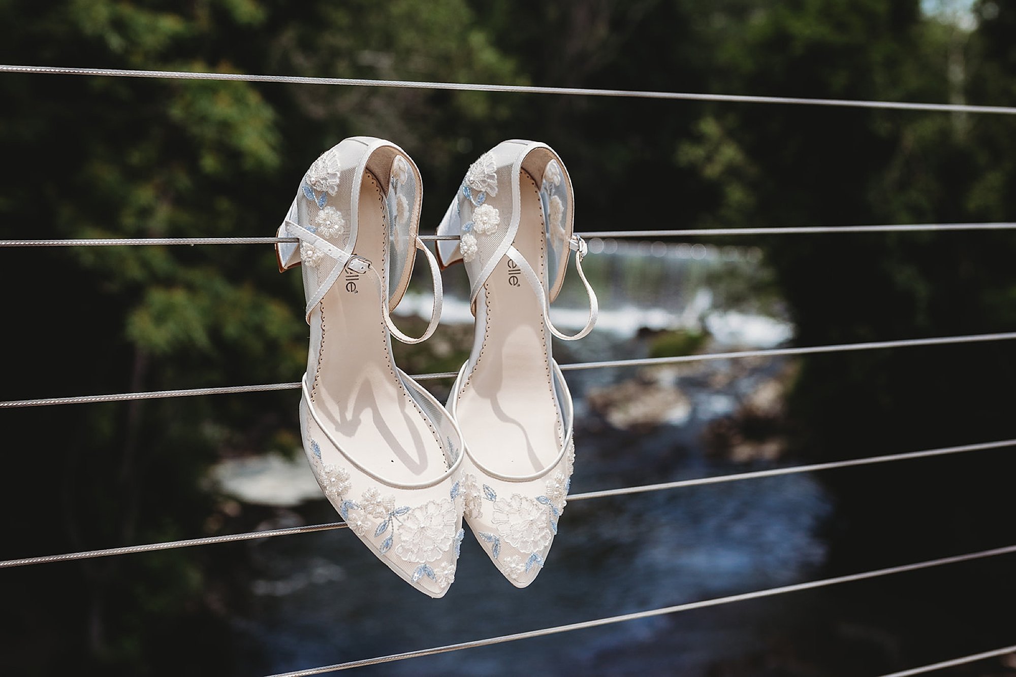 bride's white shoes hang on fence at the Roundhouse
