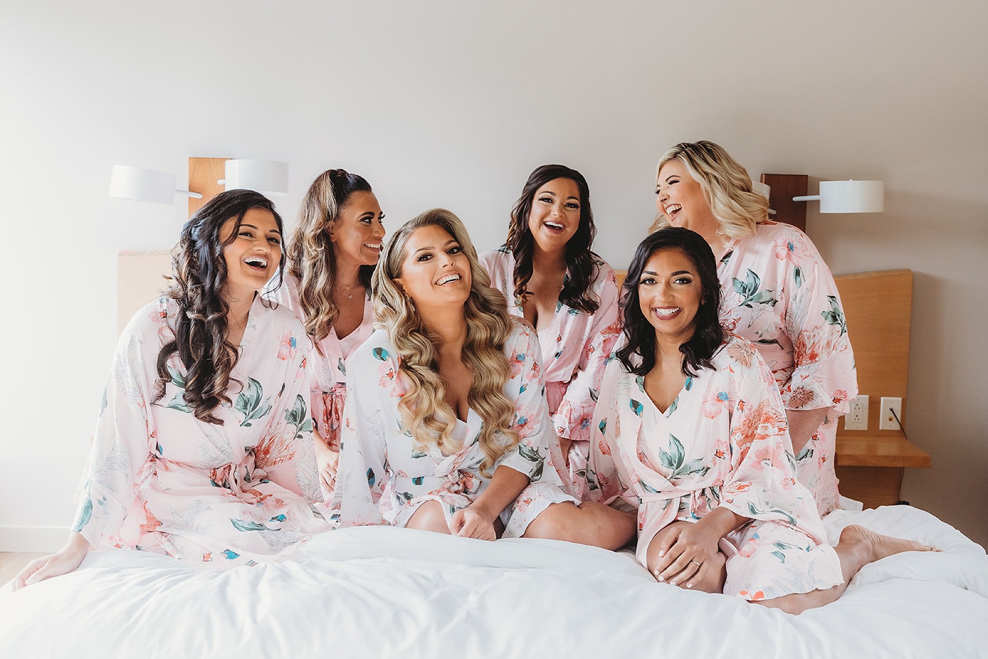 bride laughs with bridesmaids in floral robes at The Roadhouse
