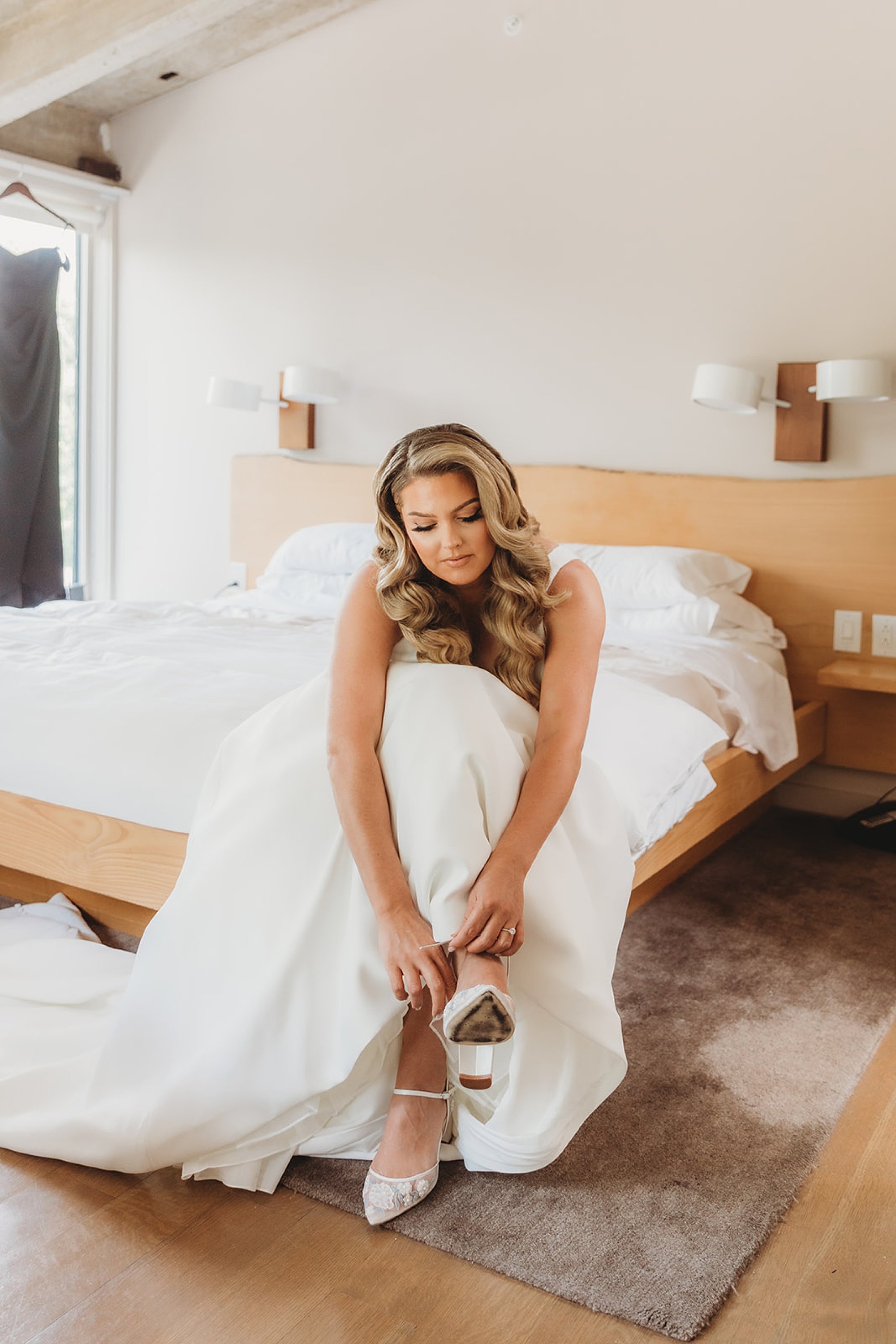 bride leans down to adjust shoe
