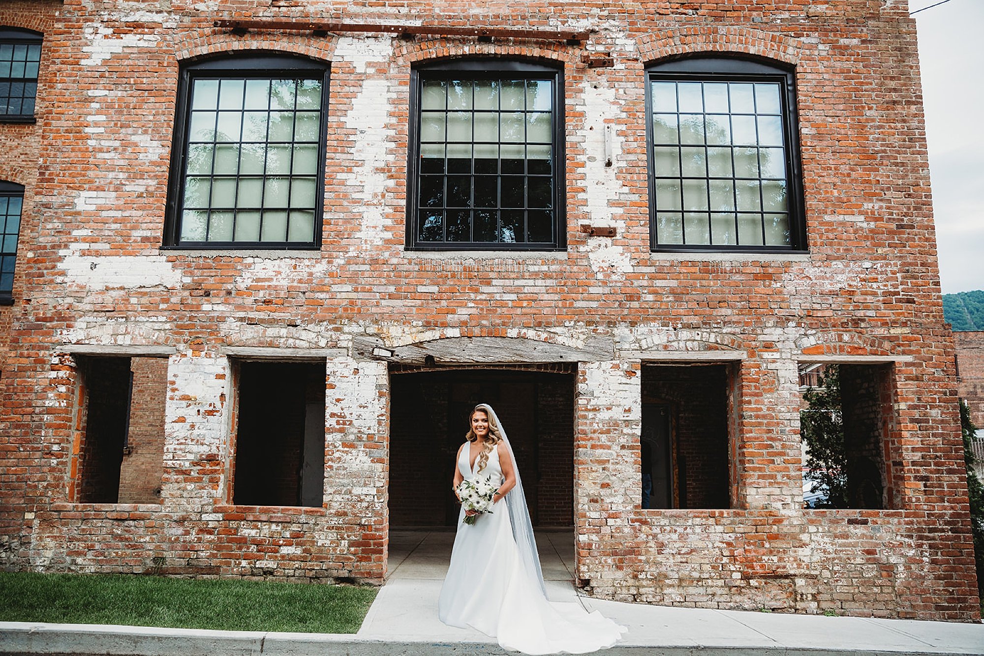 bride stands in front of brick building at The Roadhouse