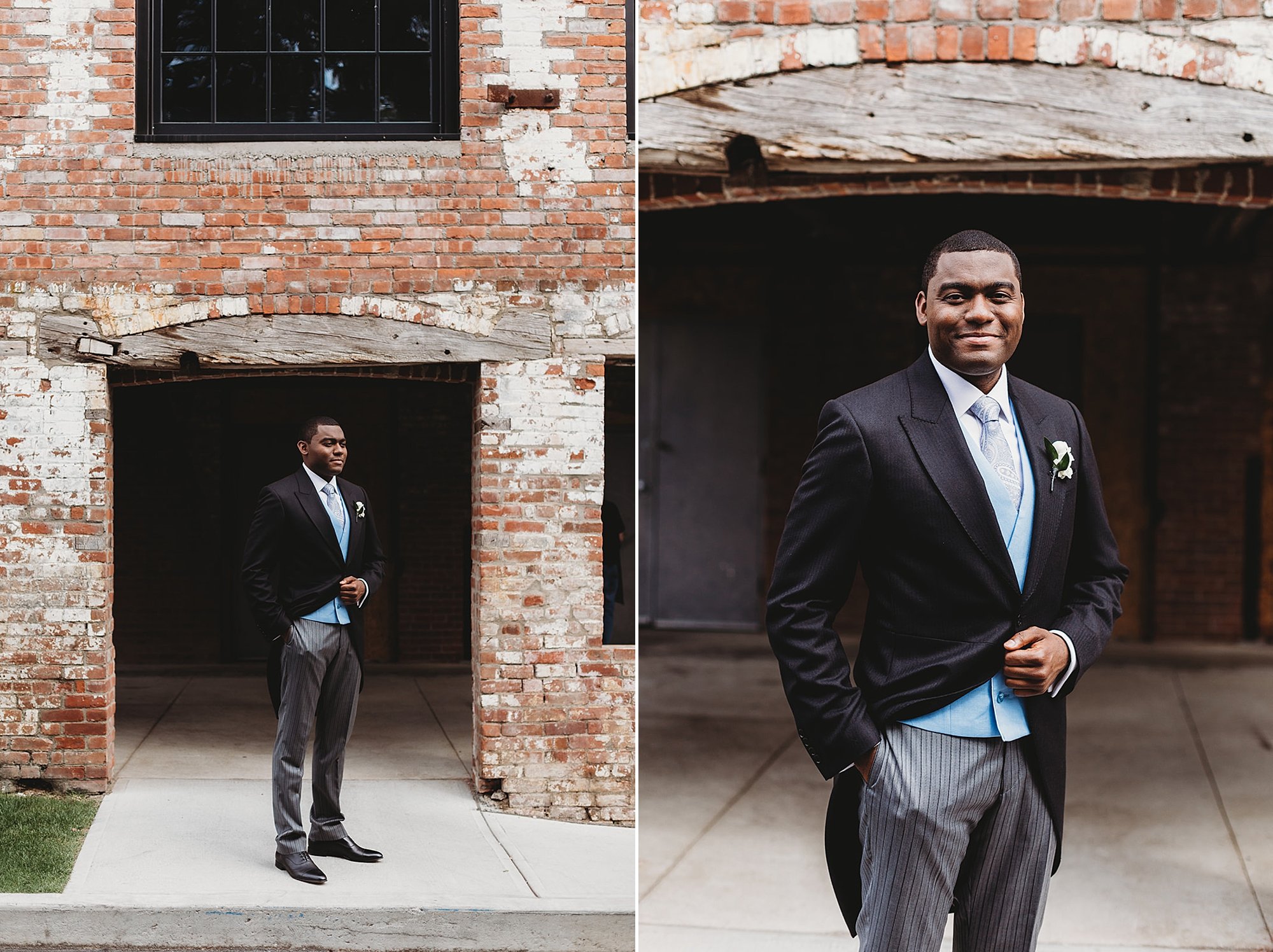 groom in black and grey English suit poses by brick wall
