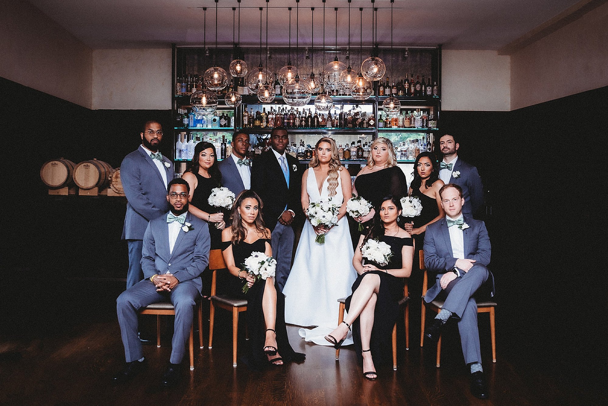 bride and groom pose with wedding party in blue and black
