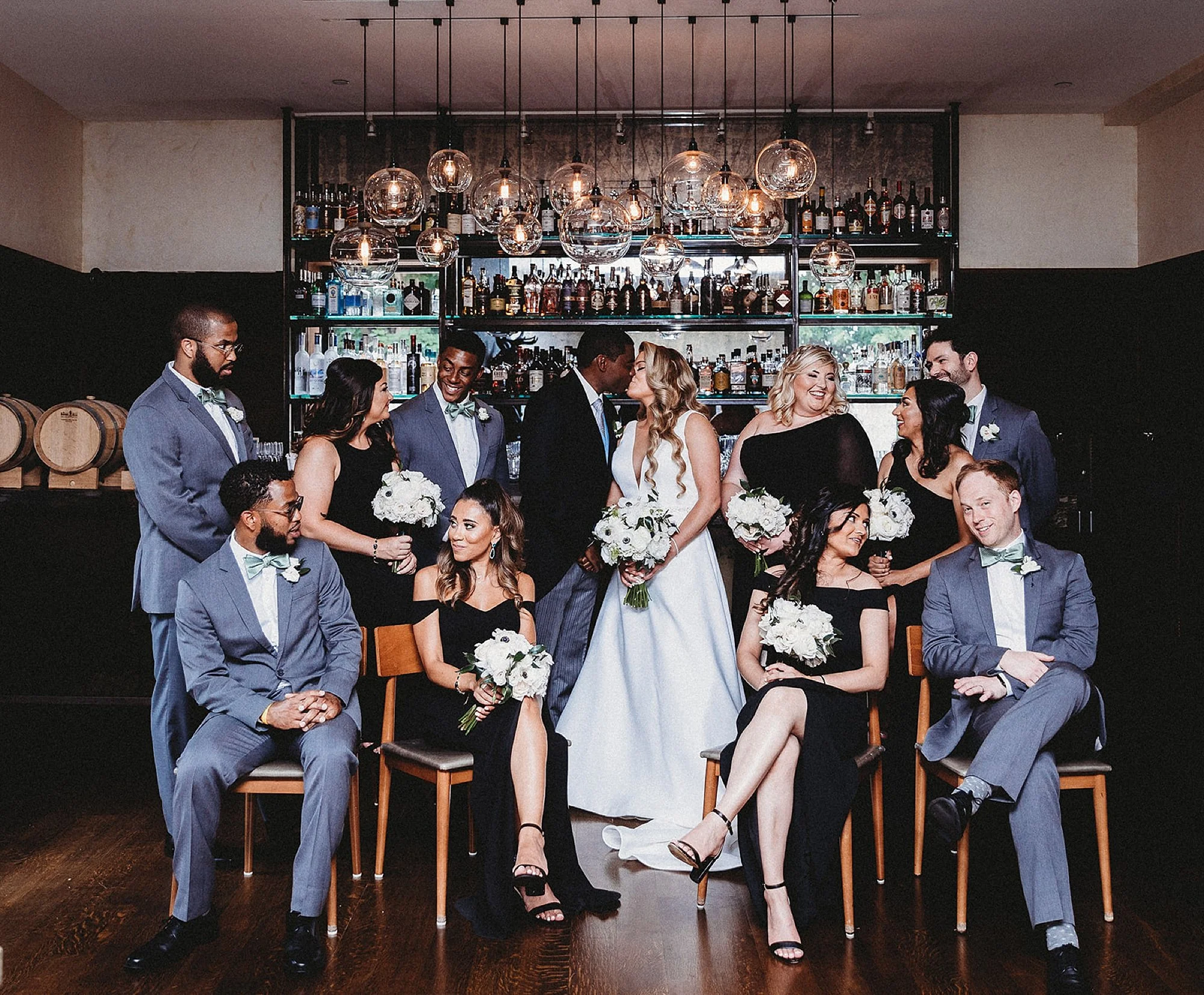 bride and groom kiss with wedding party around them at The Roadhouse