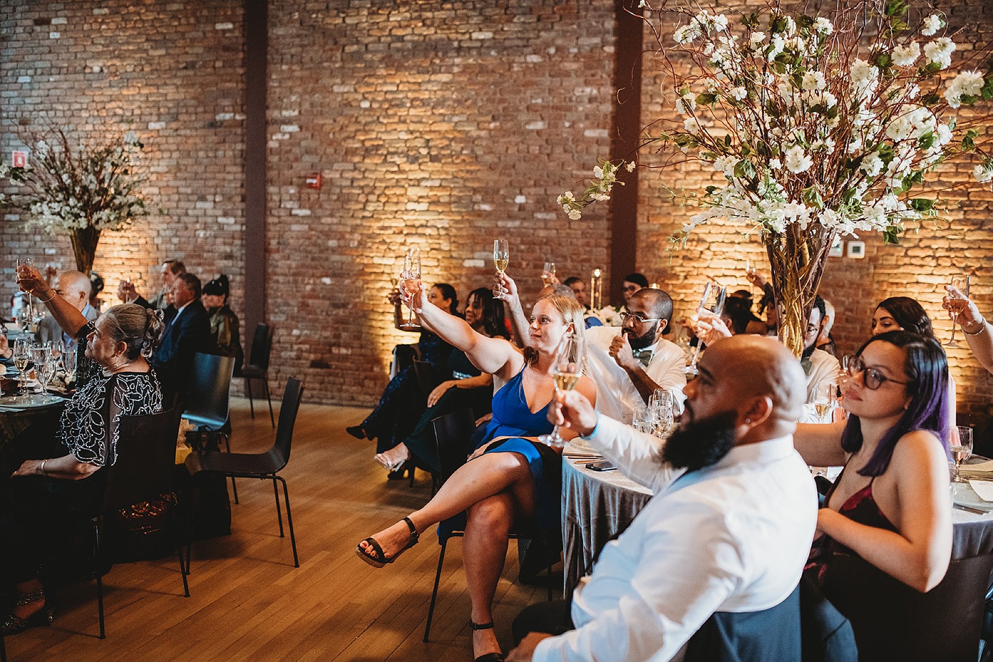guests lift champagne during toasts at Beacon NY wedding reception