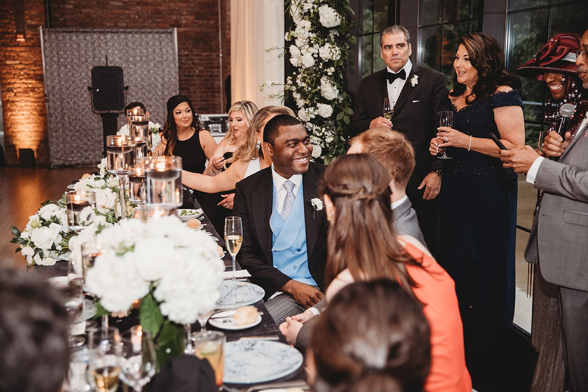 groom laughs with groomsman during toasts at Beacon NY wedding reception