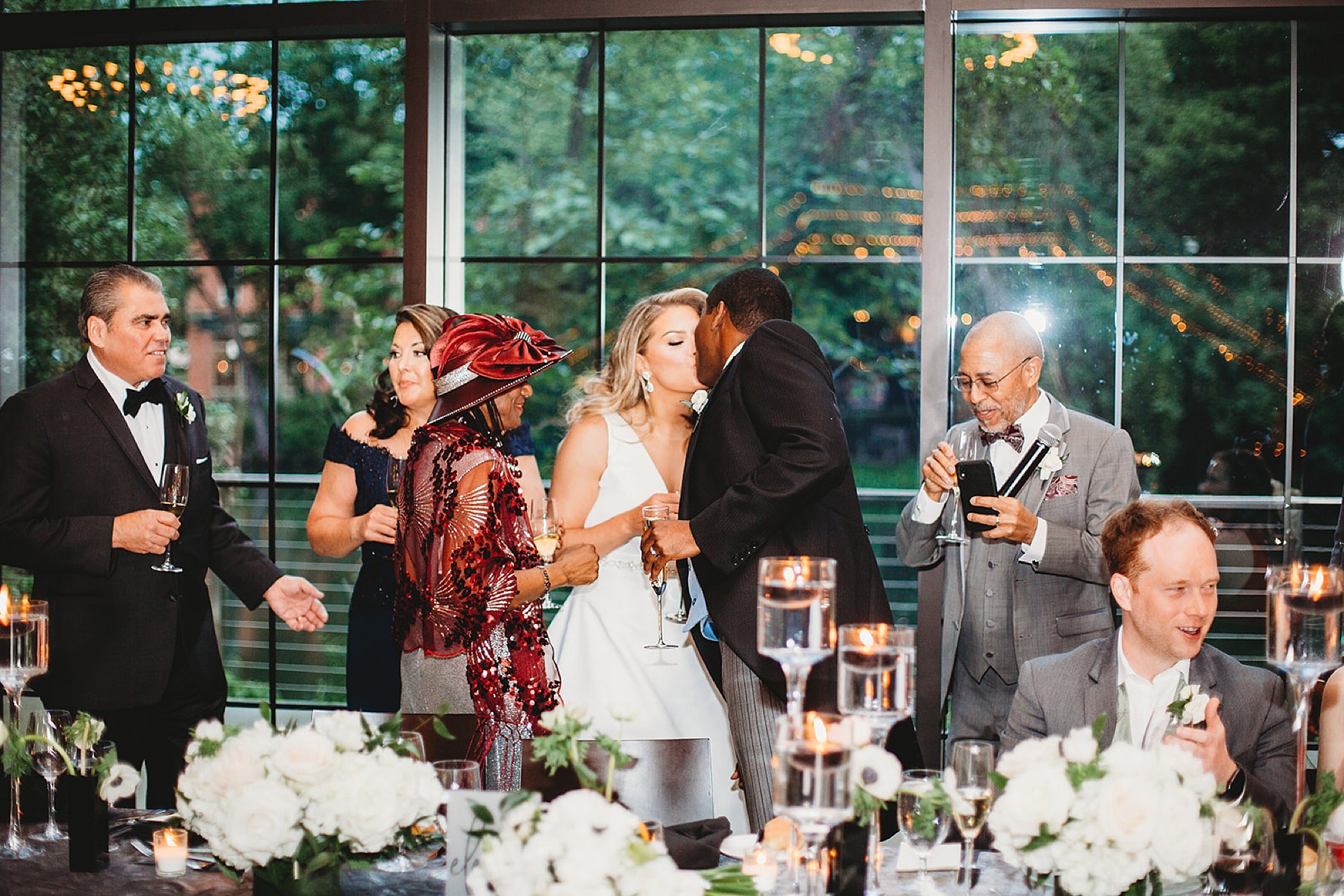 bride and groom kiss parents during toasts
