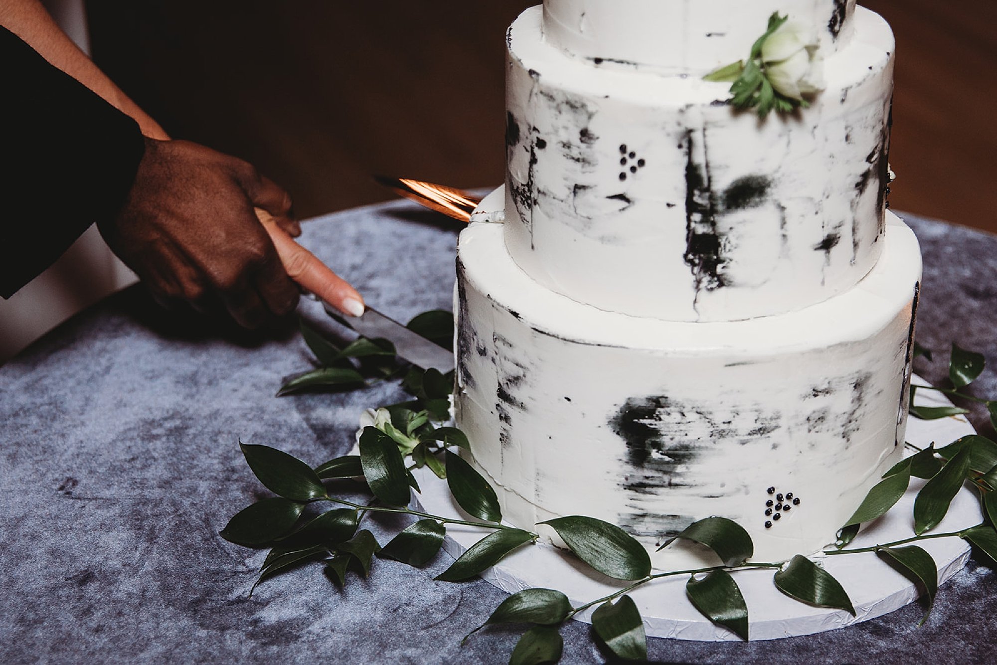 newlyweds cut wedding cake with marbled icing 