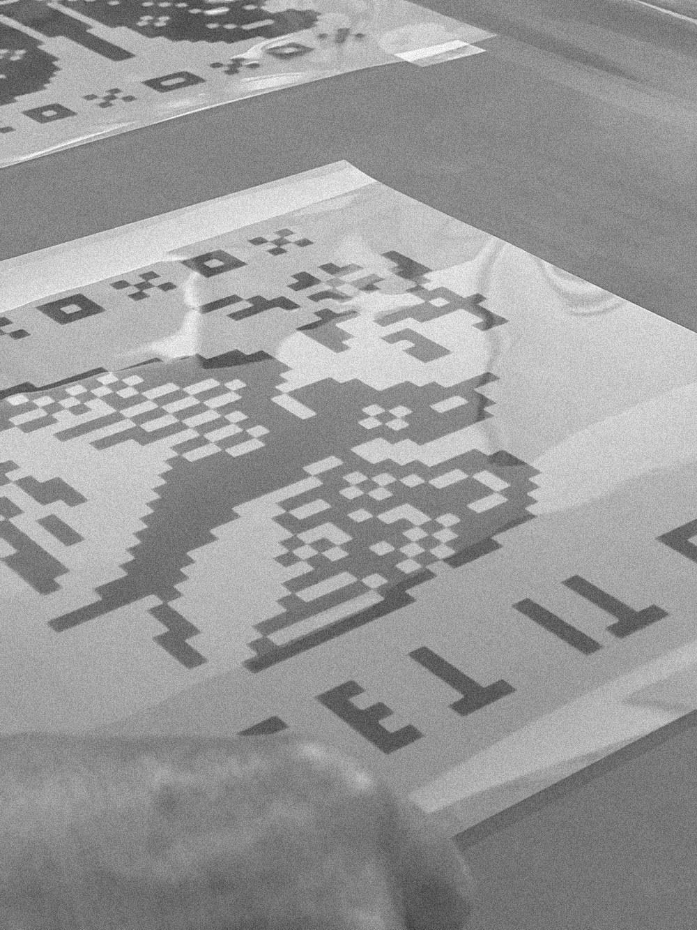 Close-up of prints with a pixelated design on a flat surface.