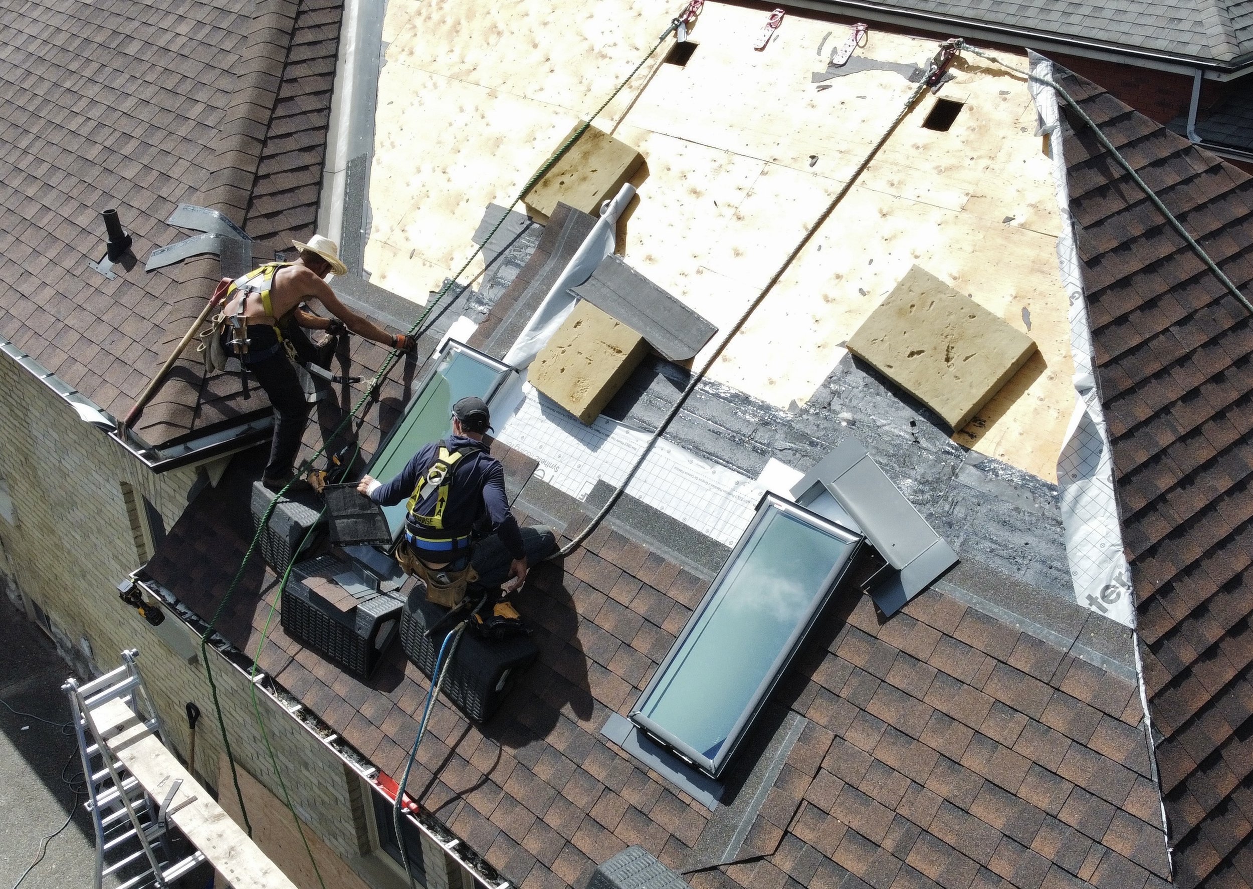 Midway through installation of Velux skylights and GAF Hickory HDZ shingles on a yellow-brick Old North residence
