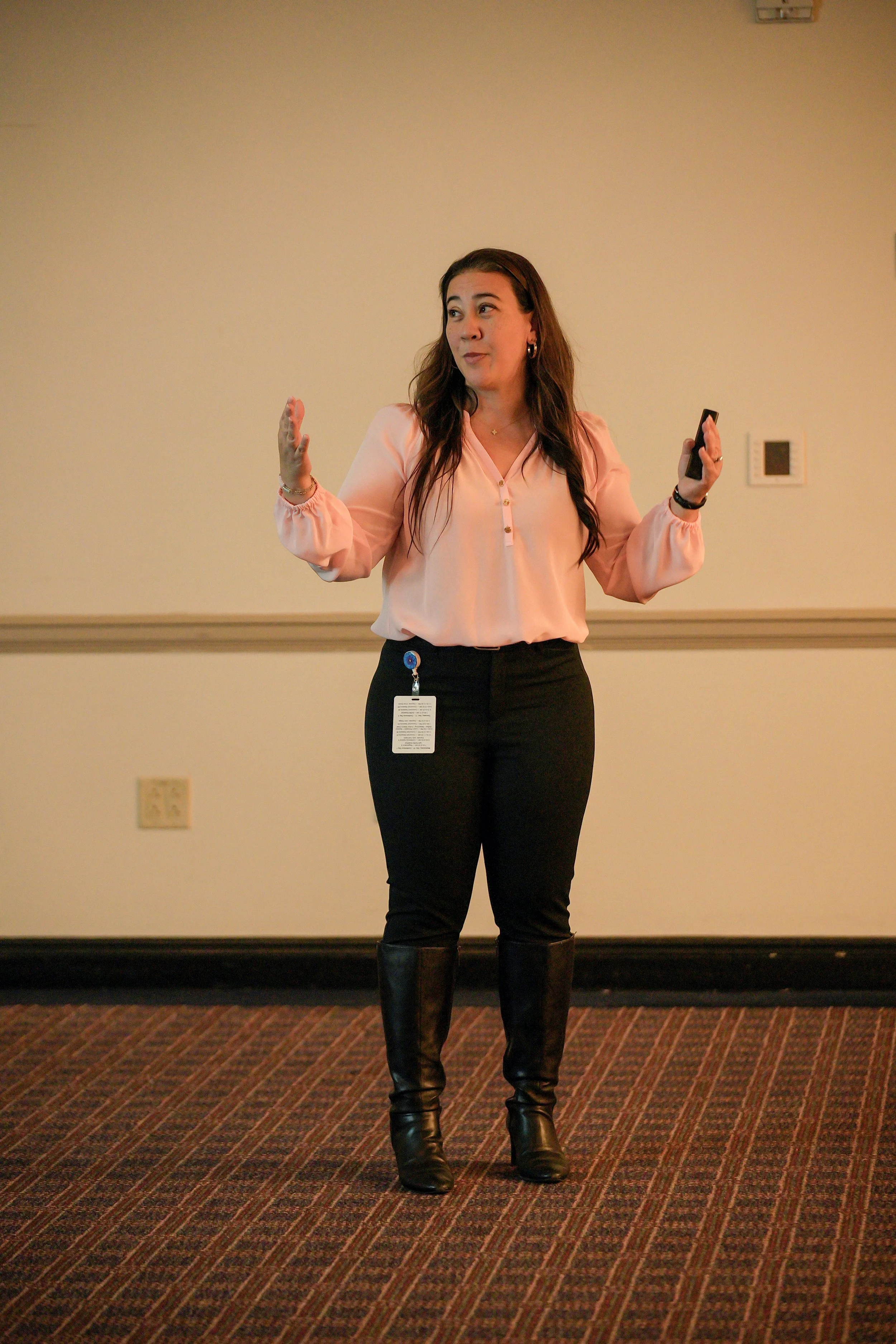 Naomi presenting in a pink shirt