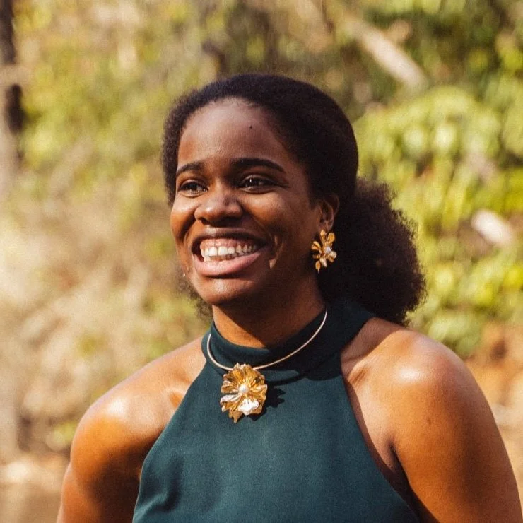 A photo of a woman smiling, looking off to the side of the camera