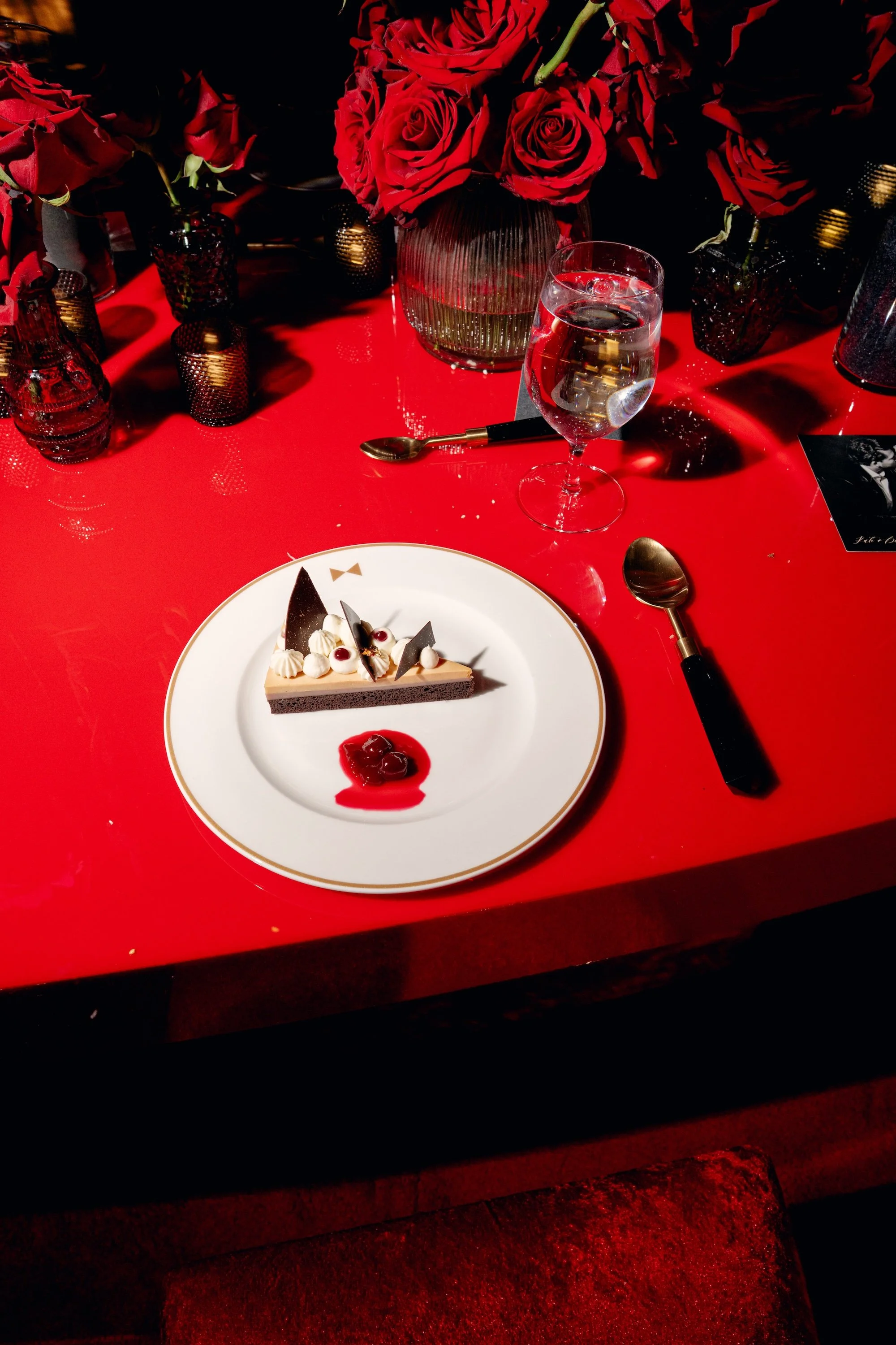 Wedding cake. Cutting the cake at a gothic and luxe wedding in Las Vegas. Red and black modern wedding reception at Fontainebleau Las Vegas.  Luxury Las Vegas Wedding Planner Andrea Eppolito.