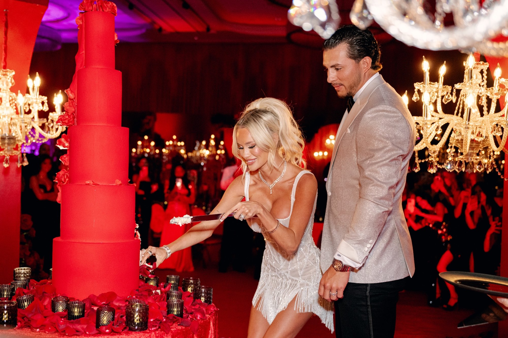 Cutting the cake at a gothic and luxe wedding in Las Vegas. Red and black modern wedding reception at Fontainebleau Las Vegas.  Luxury Las Vegas Wedding Planner Andrea Eppolito.