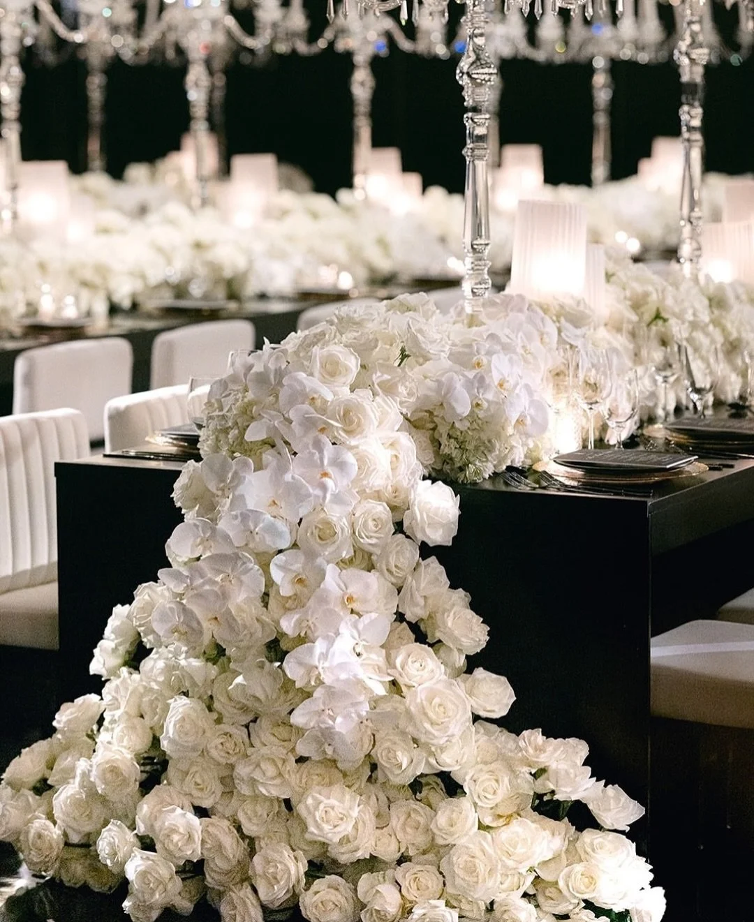Bring me all the flowers!  Make the table so full, they spill off the page!

Jessie and Rob wanted a wedding reception that was full and lush with classic elegance. Jess specifically wanted drama and contrast. 

Pristine white roses and dazzling crys
