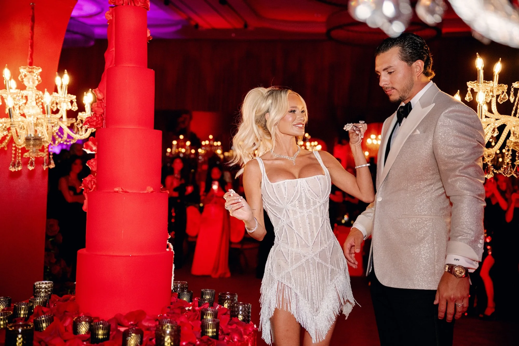 Cutting the cake at a gothic and luxe wedding in Las Vegas. Red and black modern wedding reception at Fontainebleau Las Vegas.  Luxury Las Vegas Wedding Planner Andrea Eppolito.