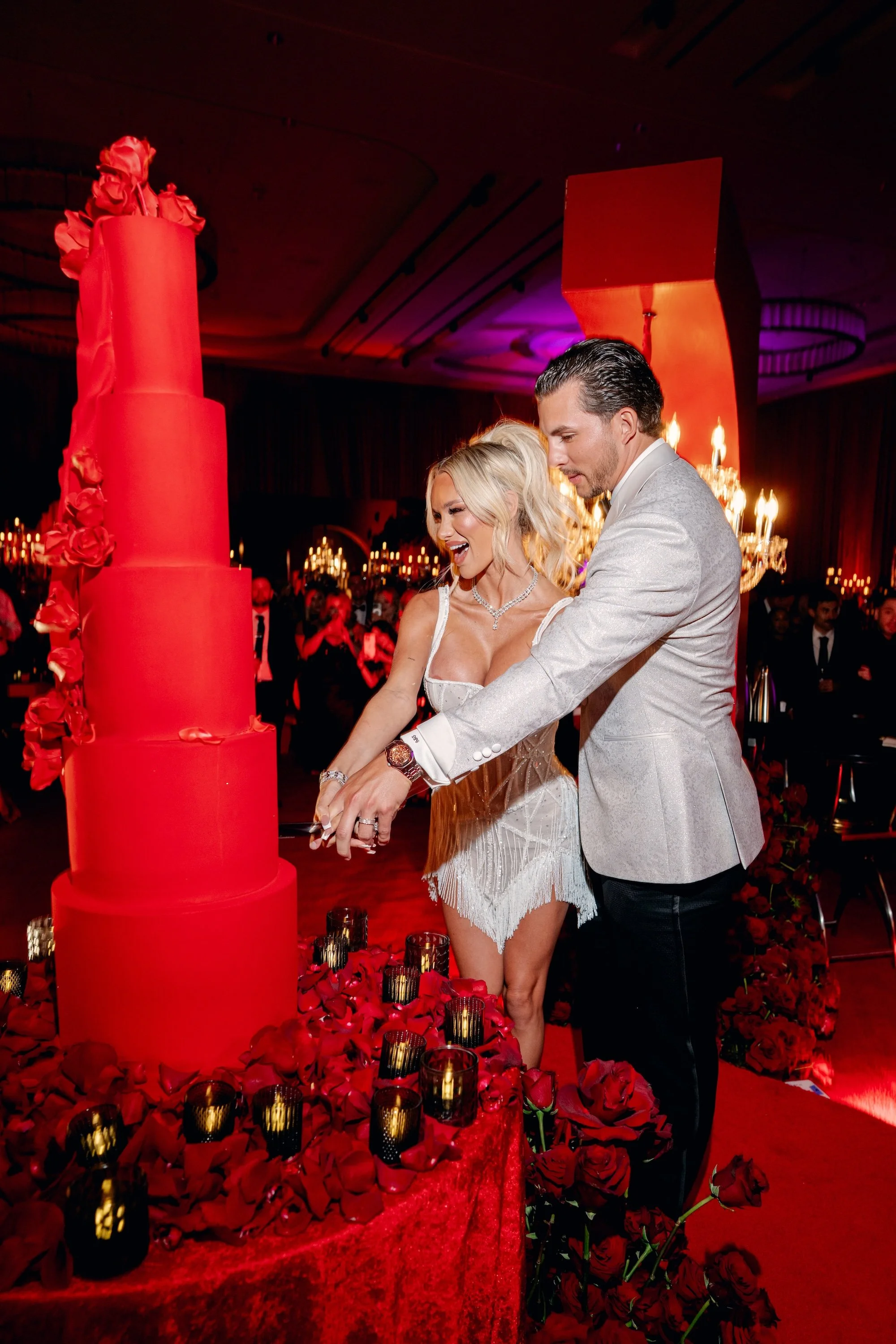 Cutting the cake at a gothic and luxe wedding in Las Vegas. Red and black modern wedding reception at Fontainebleau Las Vegas.  Luxury Las Vegas Wedding Planner Andrea Eppolito.