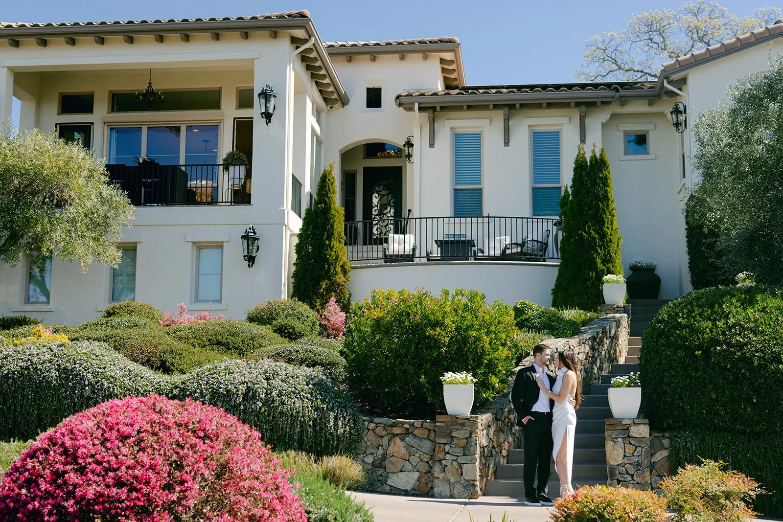 Bride and groom engagement photos in front of their home.