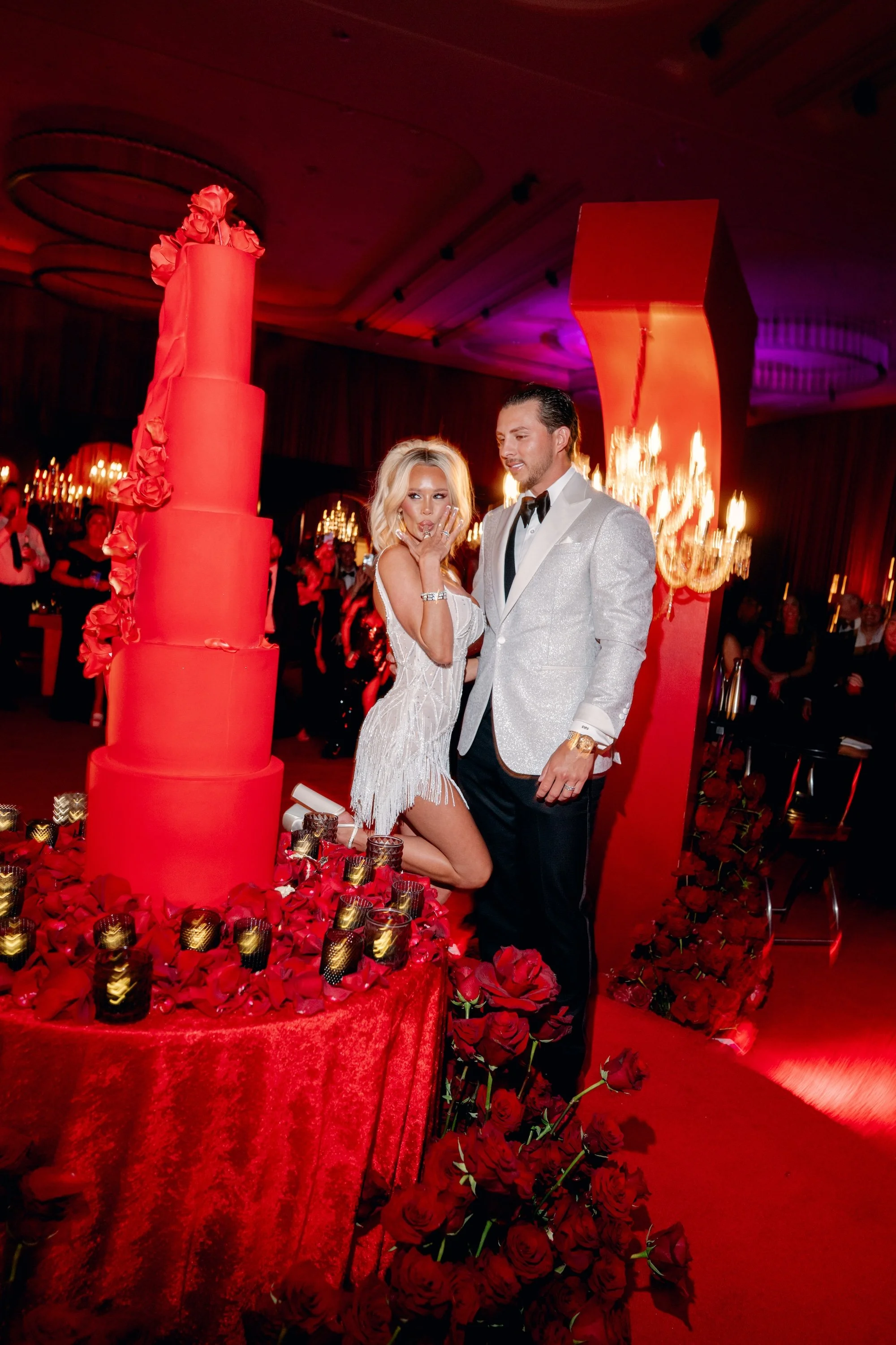 Cutting the cake at a gothic and luxe wedding in Las Vegas. Red and black modern wedding reception at Fontainebleau Las Vegas.  Luxury Las Vegas Wedding Planner Andrea Eppolito.