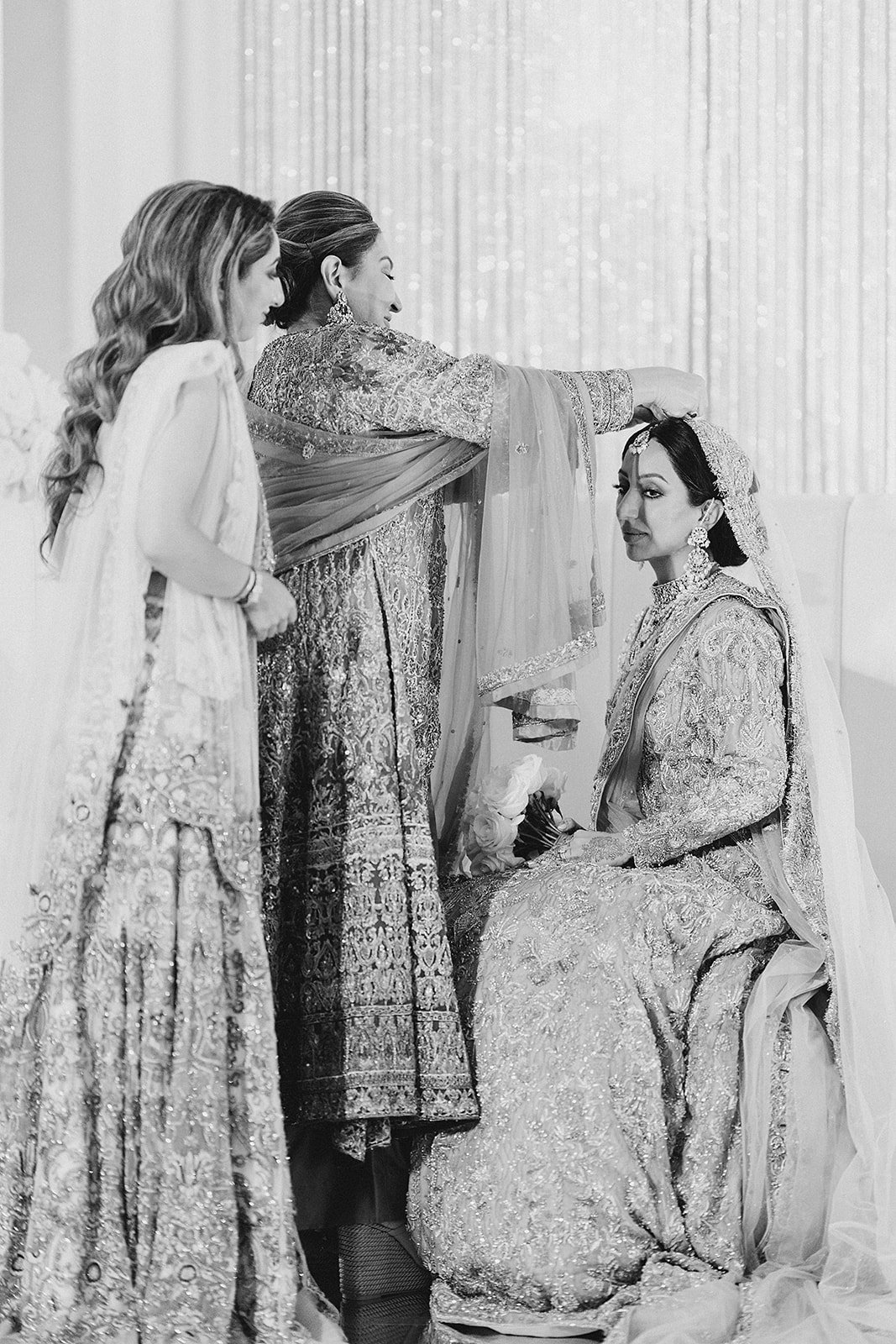 Indian bride being dressed by family