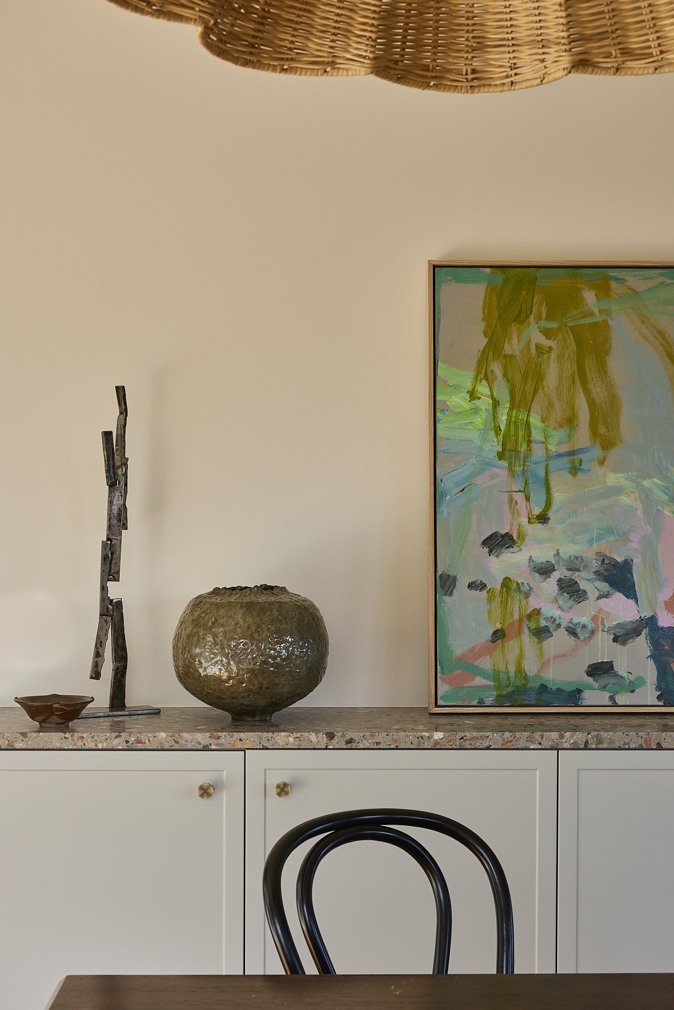 Terrazzo kitchen benchtop detail with brass hardware, custom pale blue cabinetry and sculptural ceramic platter in a contemporary Australian kitchen renovation.