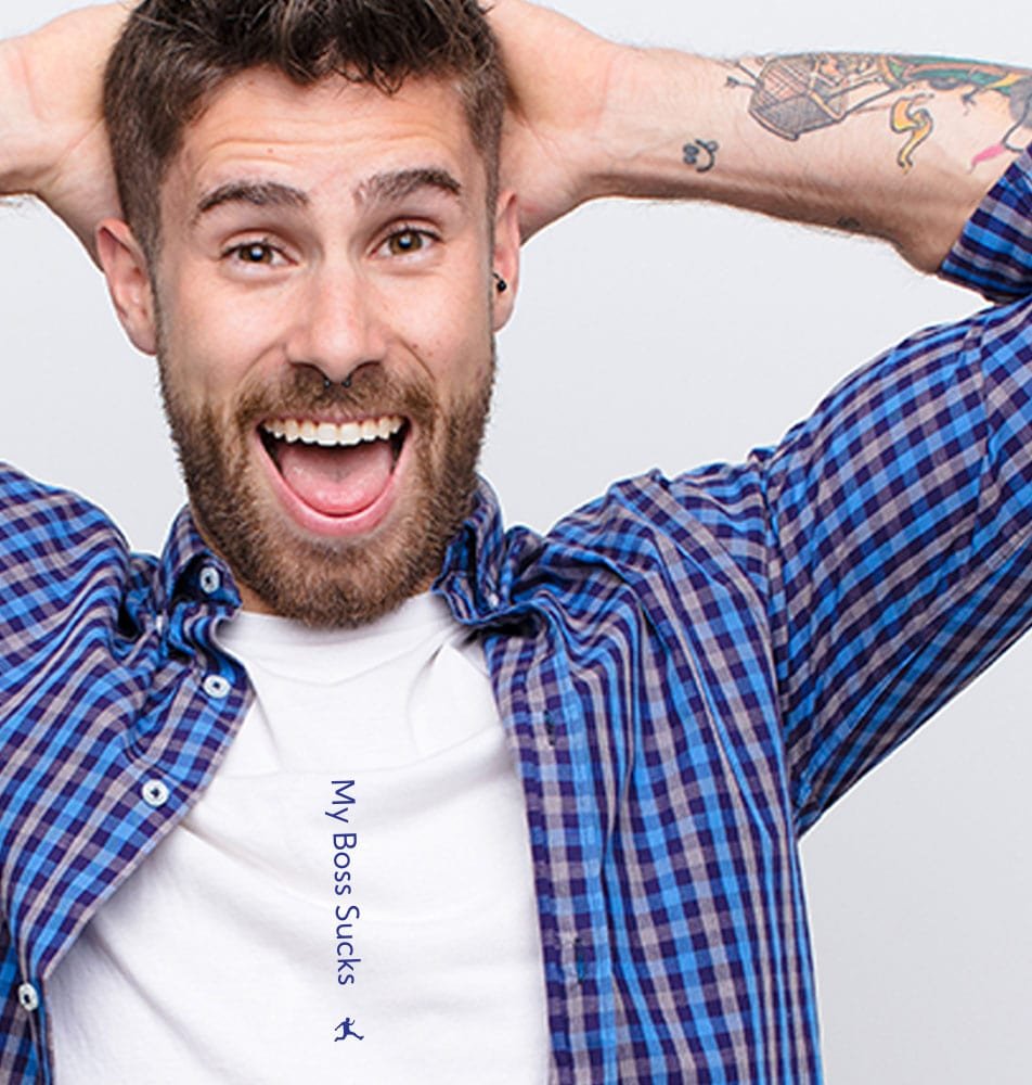 A cool guy with tattoos is wearing a dress shirt that's open to reveal that his white Graphic Undershirt has an incognito message that reads "My Boss Sucks". He looks pretty darned amused.