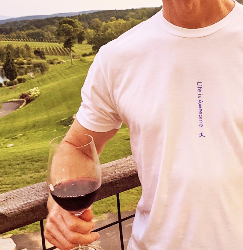 Mr. Wonderful is showing off his perfect white tee with a beautiful vineyard in the background. He's drinking a glass of red wine. You can see that his high quality shirt reads "Life is Awesome". You would never know that this shirt also functions as