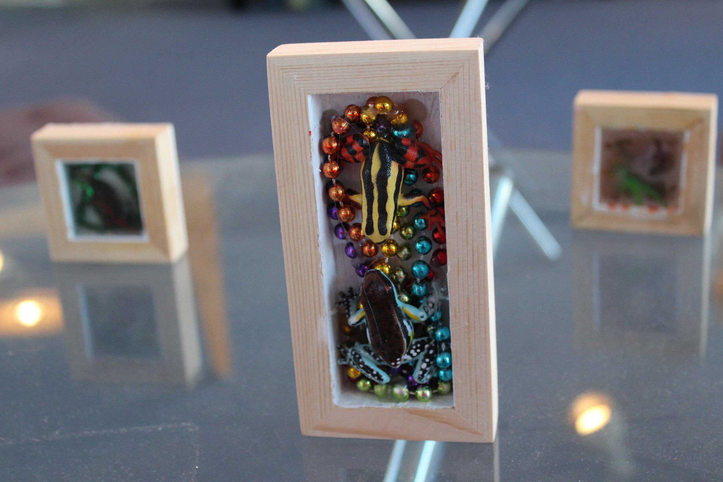 rainbow frogs behind chair painting