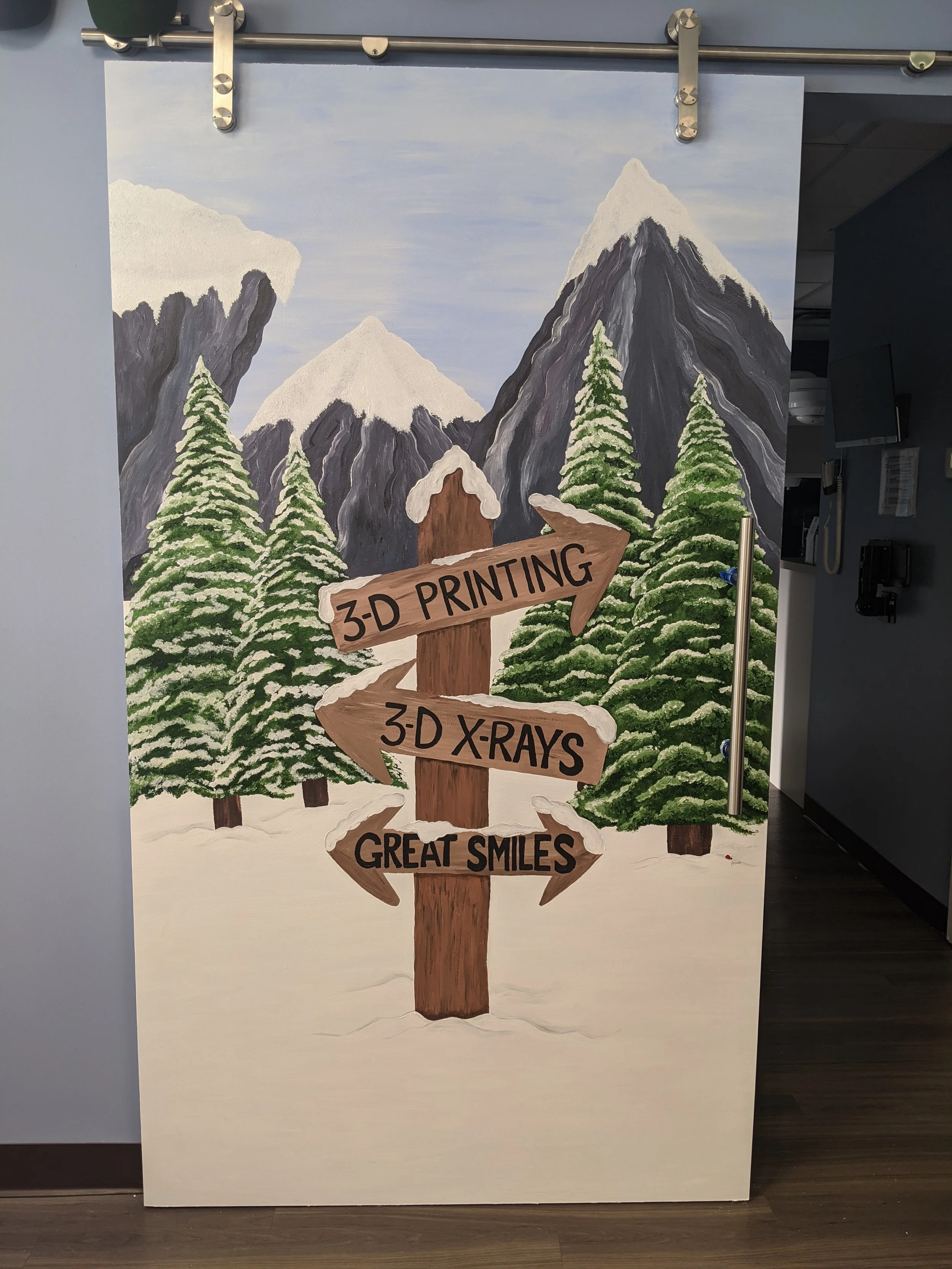 Directional sign in front of snowy mountains and trees pointing the way to great smiles, 3D x-rays and 3D printing