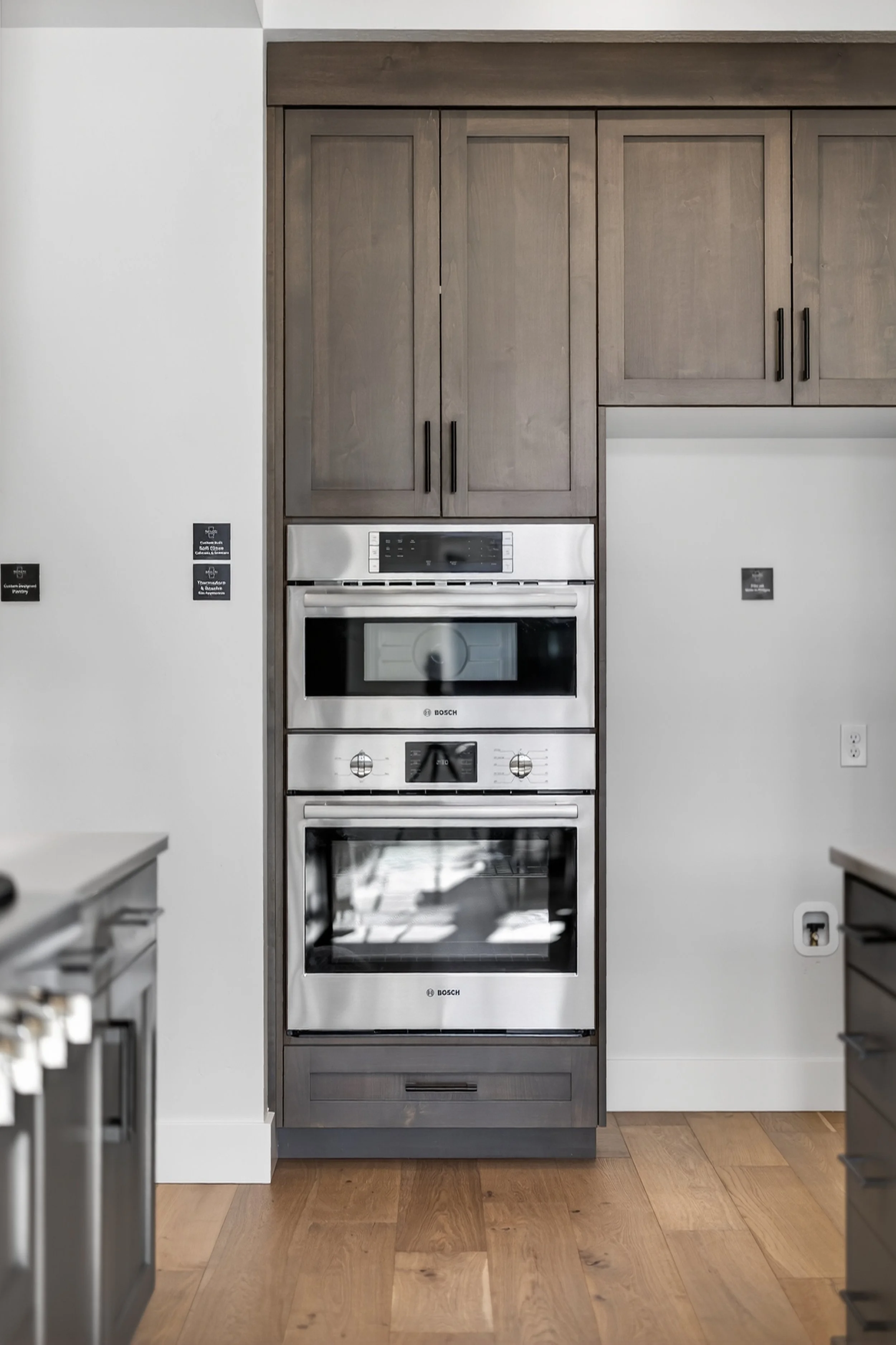 Kitchen with a built-in double oven in a gray wood cabinet.