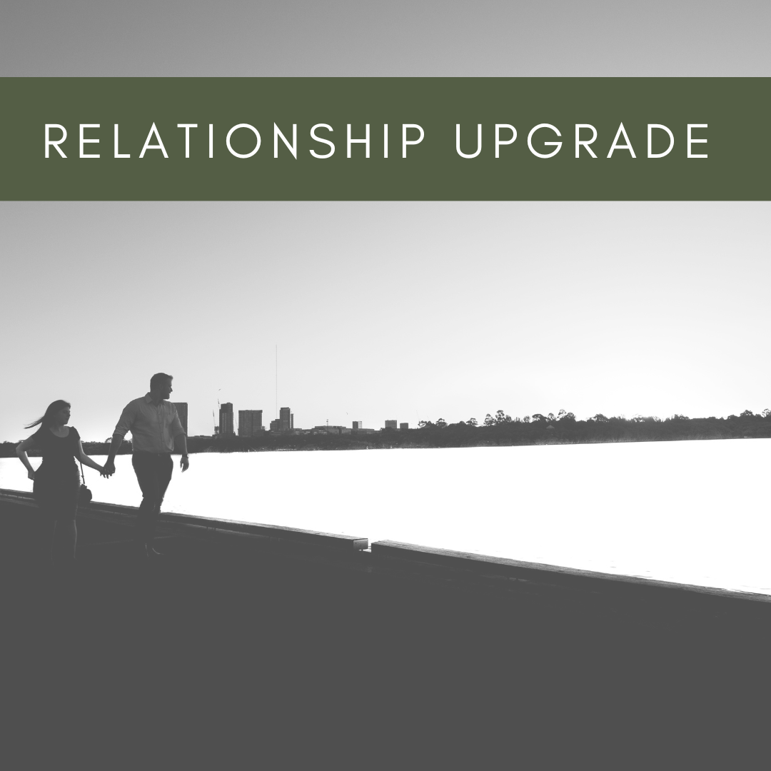 Silhouettes of a man and woman walking hand in hand by a waterfront with a city skyline in the background, overlaid with text 'Relationship Upgrade'.