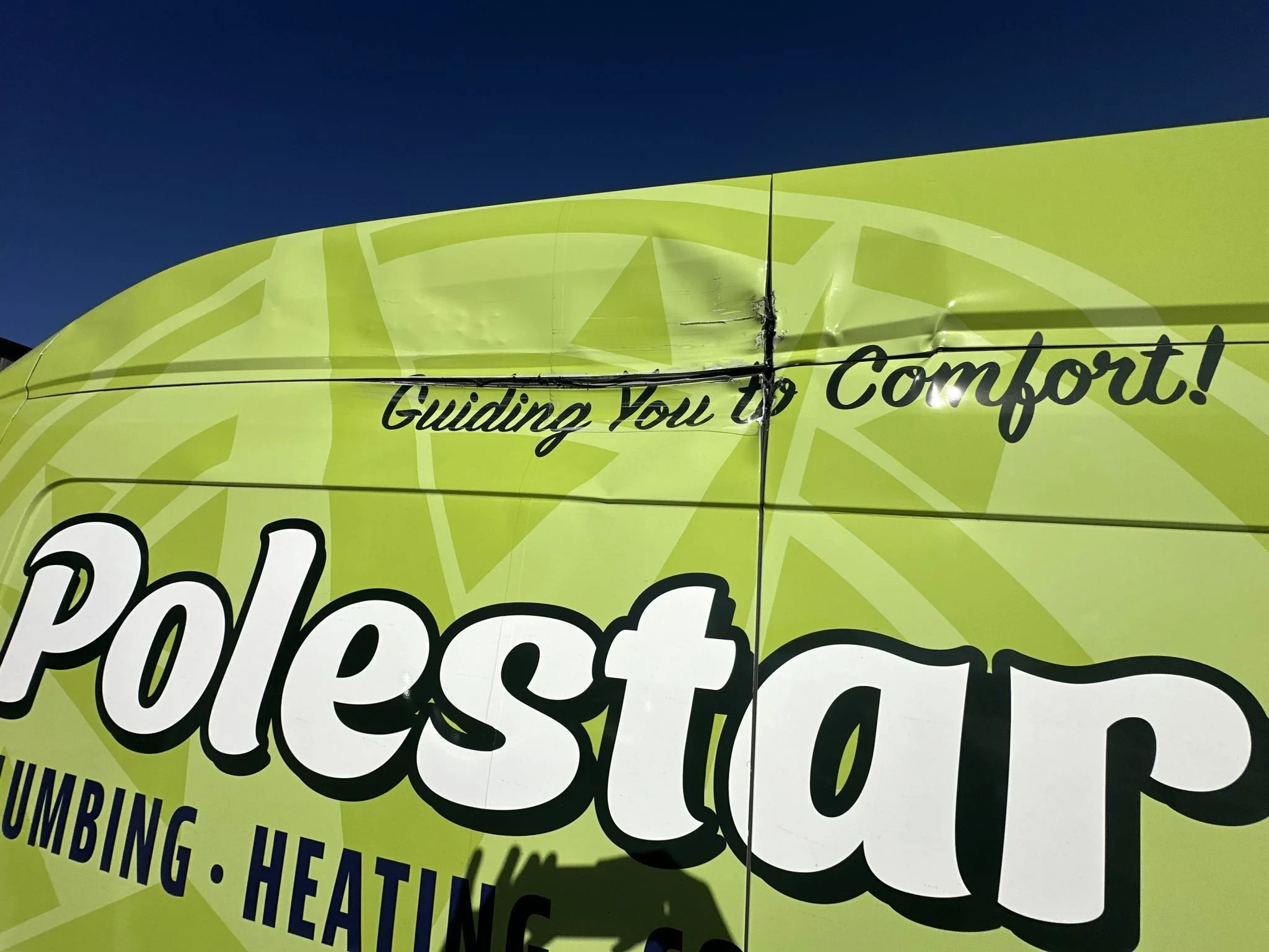 Close-up of a bright yellow vehicle with partial text that reads 'Guiding You to Comfort!' and other words like 'Pope...' and 'Umbing' visible.