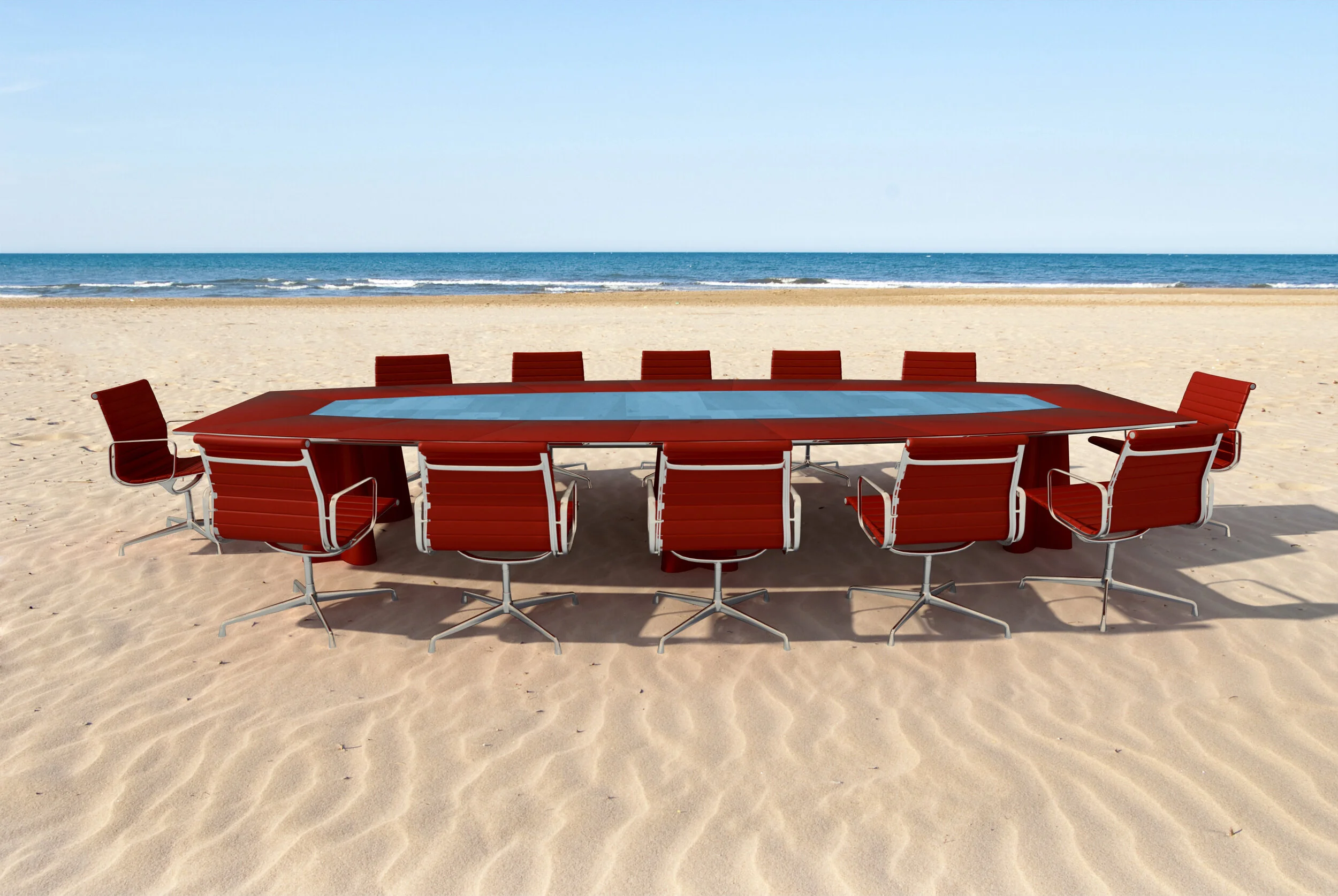 Roter Konferenztisch mit roten Stühlen am Strand und das Meer im Hintergrund