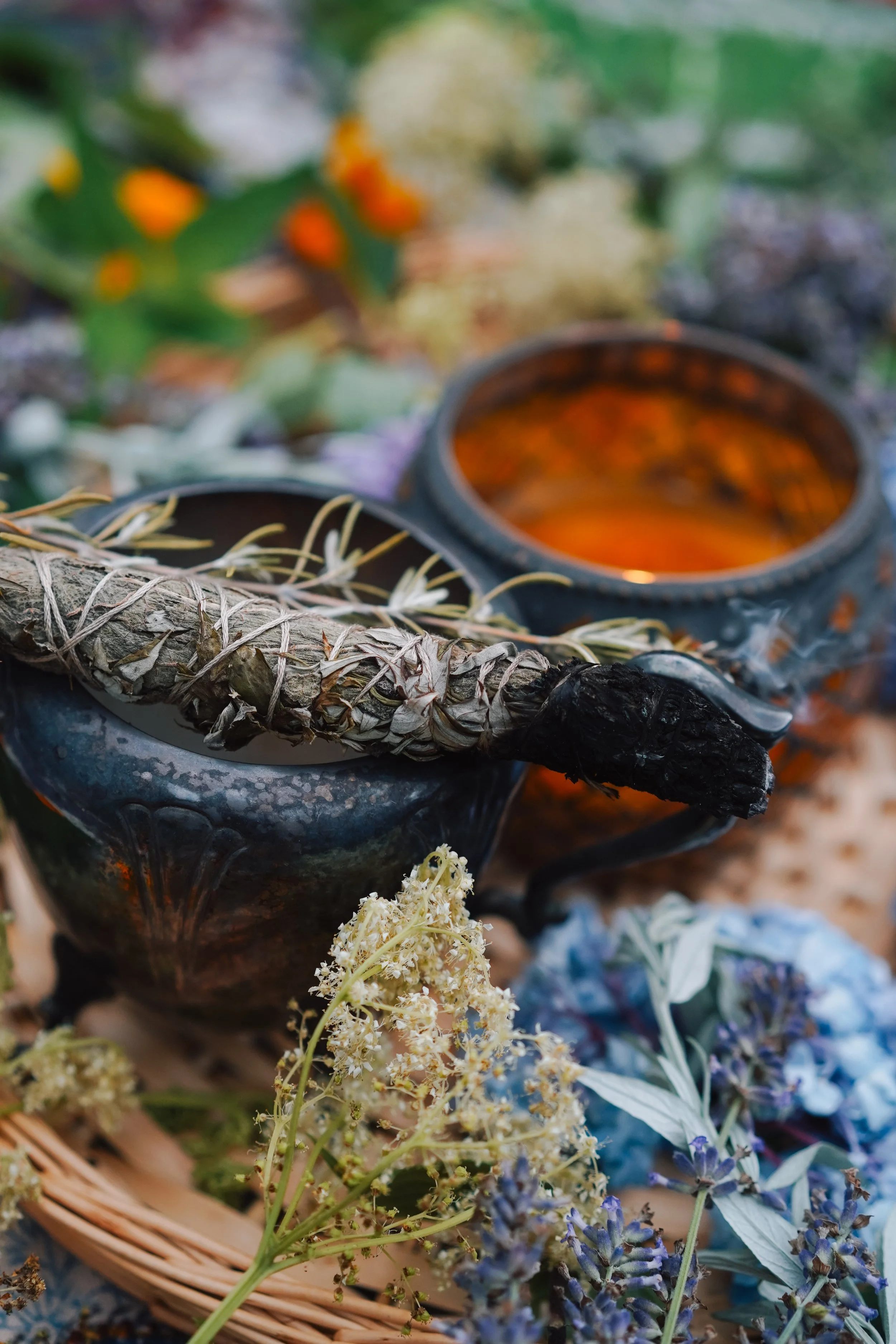 burning bundle on silver cup with candle in background.jpg