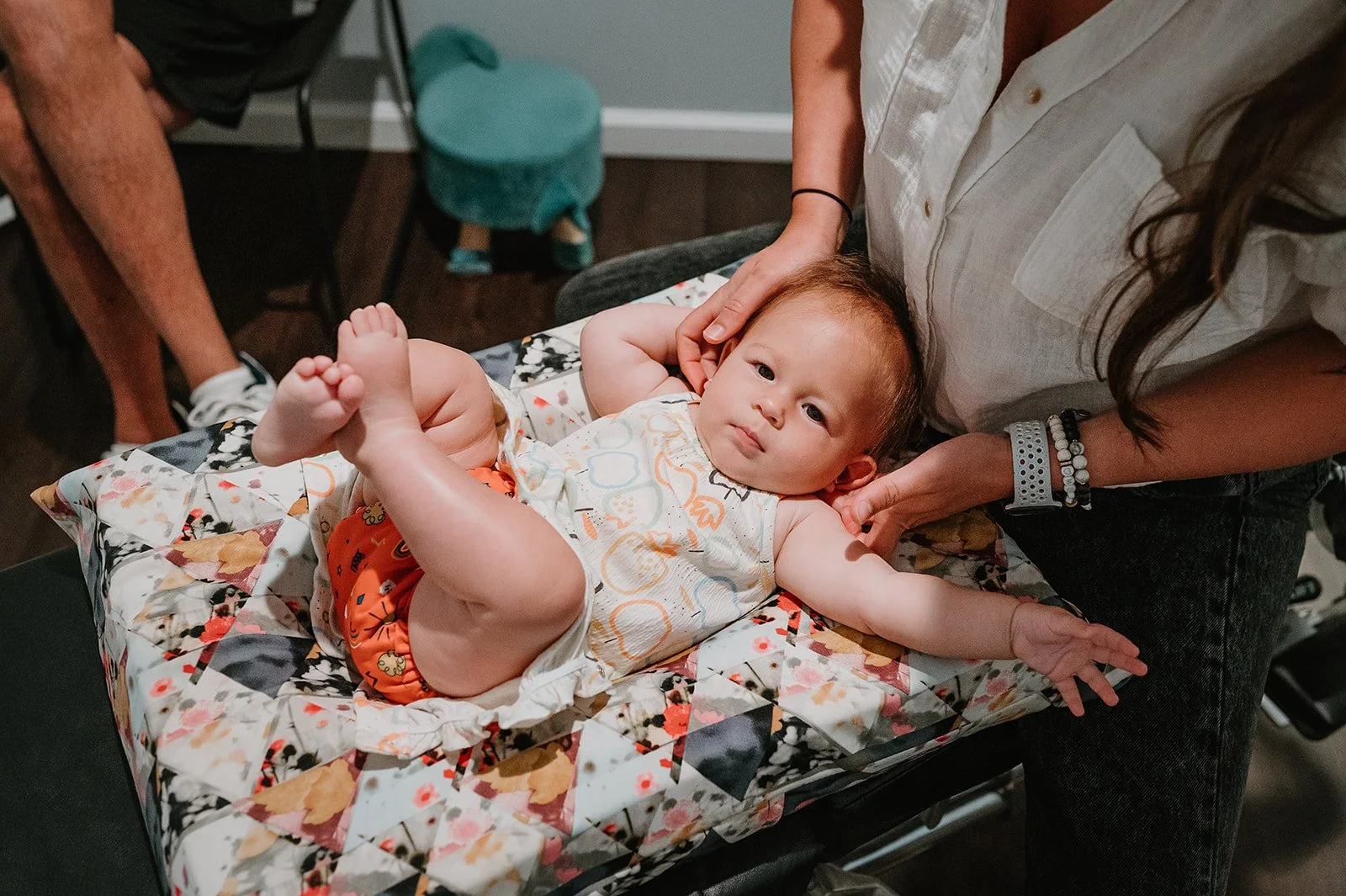 Chiropractor gently assessing a baby during a pediatric chiropractic visit at MCH Chiropractic in Matthews NC