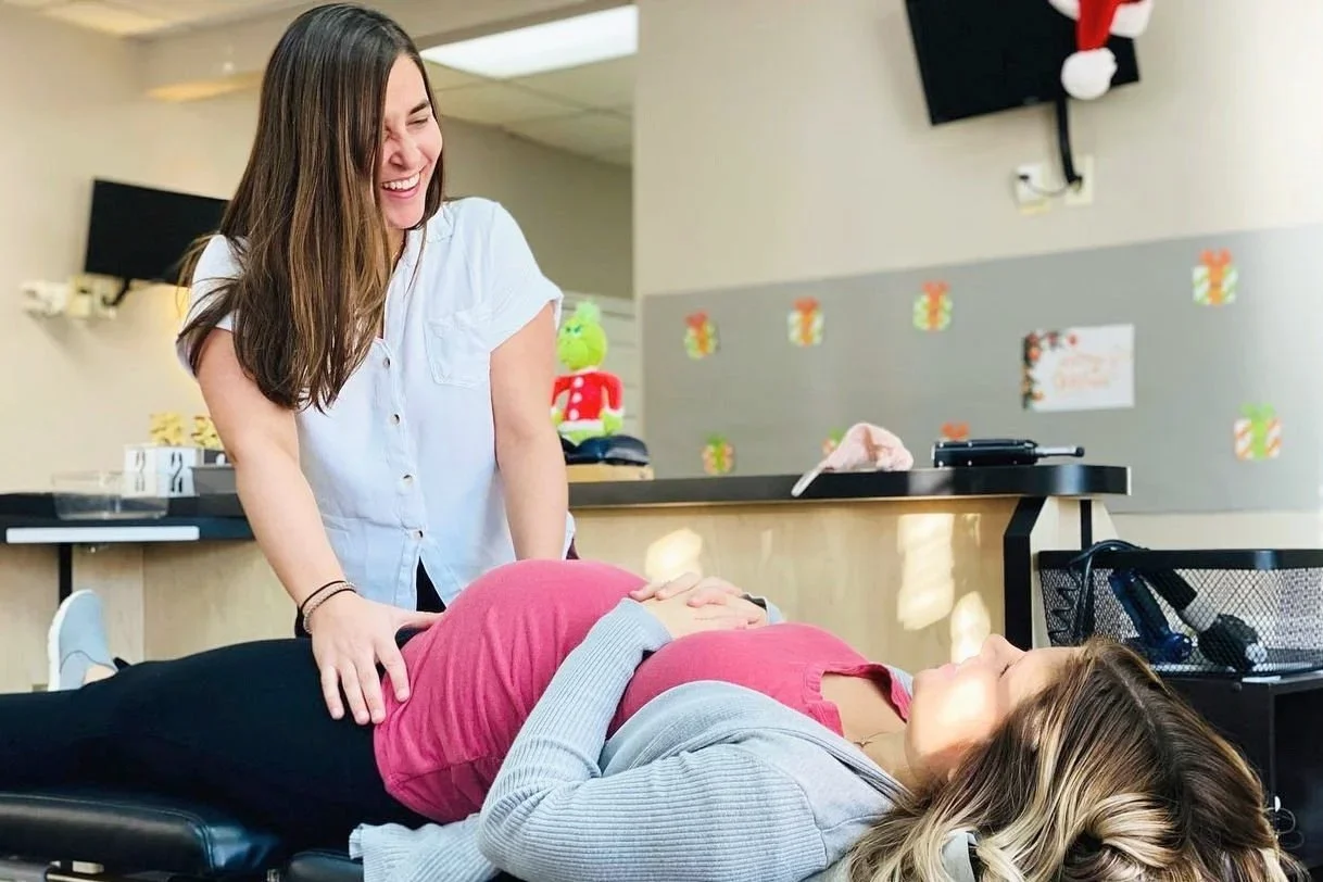 Chiropractor gently performing a prenatal adjustment on a pregnant patient in a welcoming chiropractic office setting.