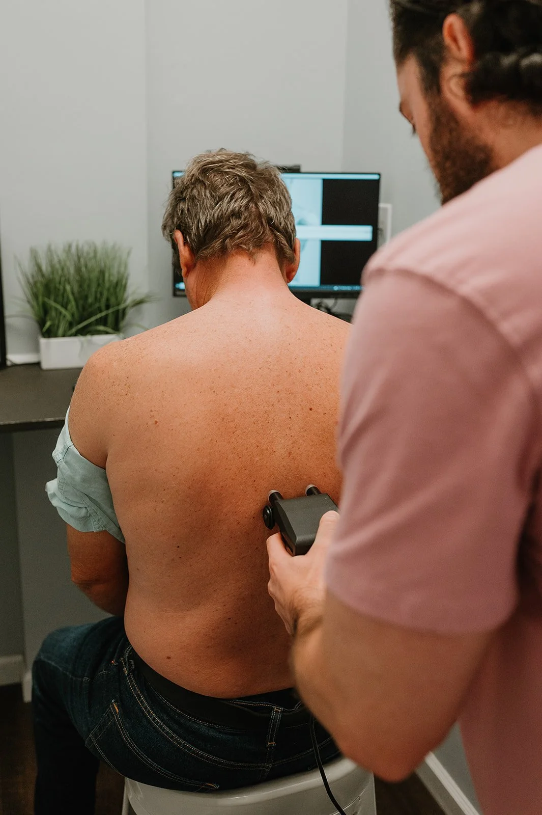 Chiropractor performing a full-spine thermal scan on a patient using infrared technology at MCH Chiropractic in Matthews NC